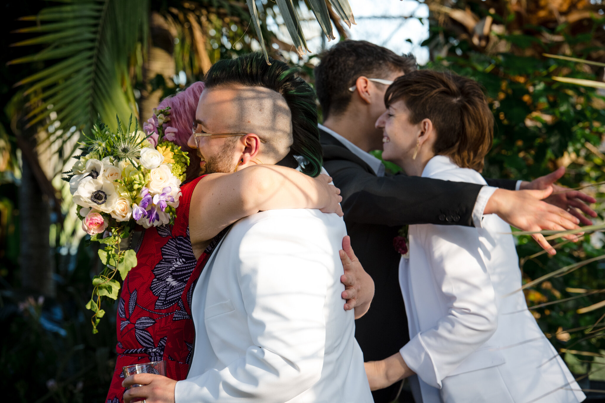 Marriers hug wedding guests during reception at Roger Williams Botanical Center Providence Rhode Island Michelle Schapiro New England LGBTQ Photographer