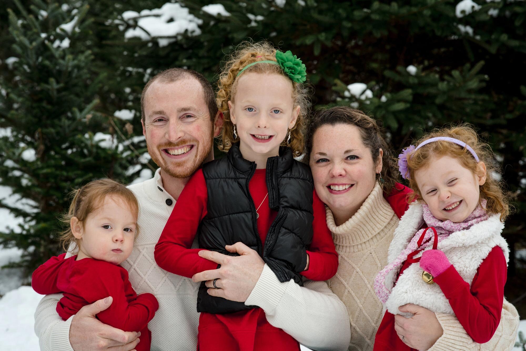 Parents and three young children wear red and white outfits during winter family session Michelle Schapiro Photography