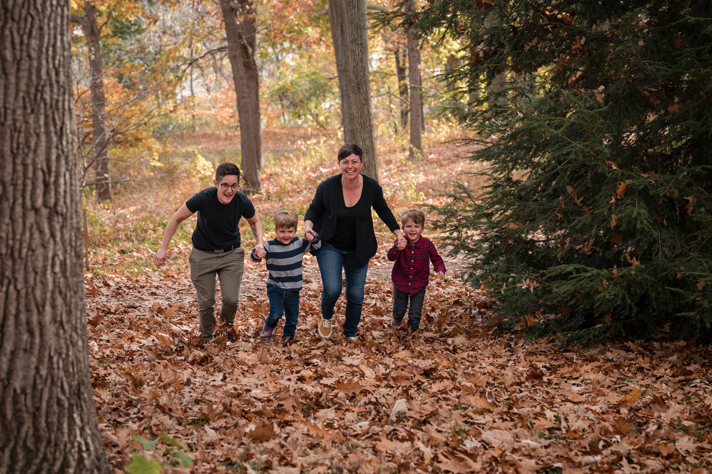 LGBT family walk in fall foliage in boston park by family photographer Michelle Schapiro