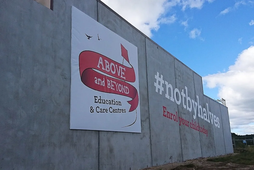 Large Sign with Painted Graphics on concrete - Above & Beyond