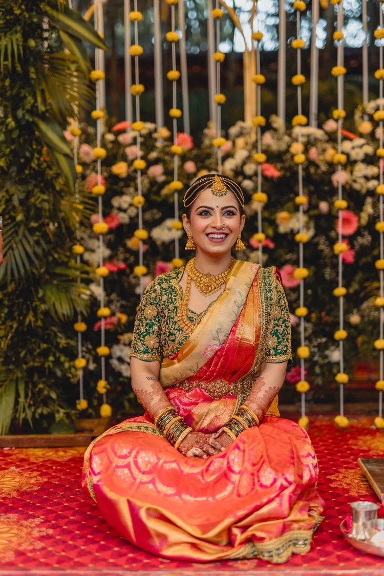 Bride seated before a marigold backdrop