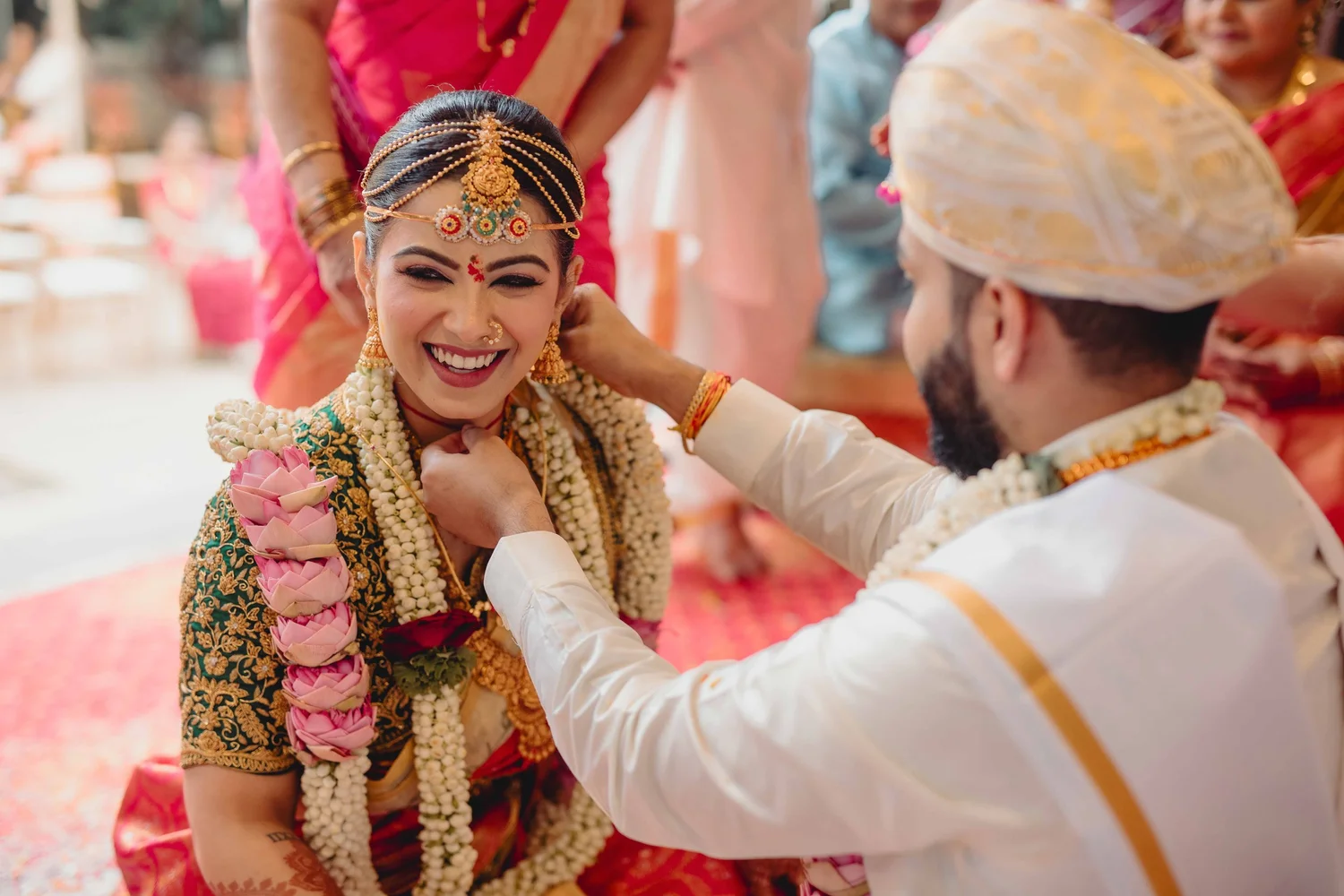 Groom placing a garland on the smiling bride