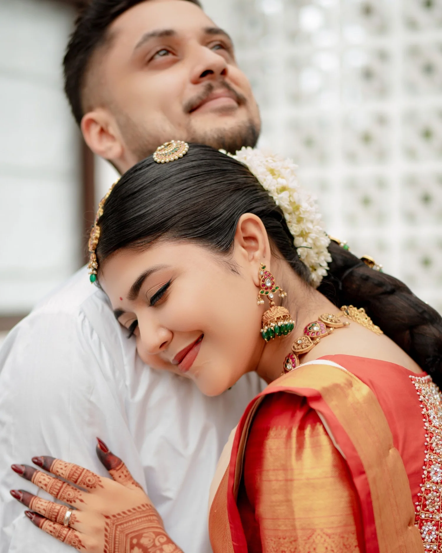 Bride smiling with her eyes closed as she hugs the groom, photographed by Shutter Clicks