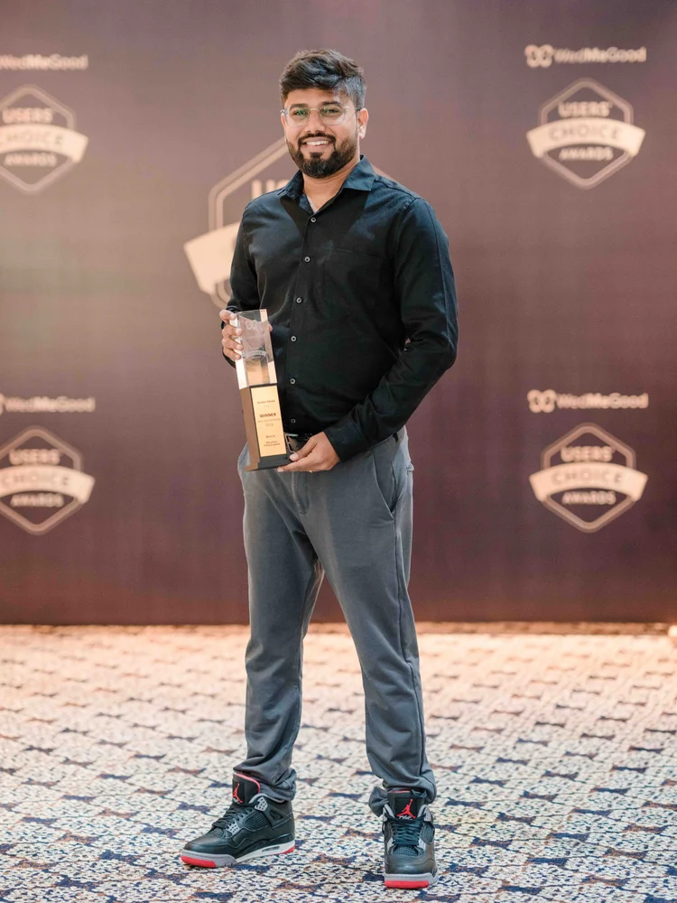 Ganesh Umari holding a WedMeGood Users' Choice award