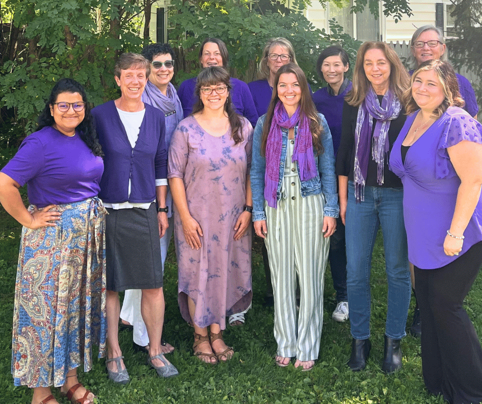 El equipo del Proyecto SAGE viste de púrpura en el exterior sobre un fondo verde frondoso