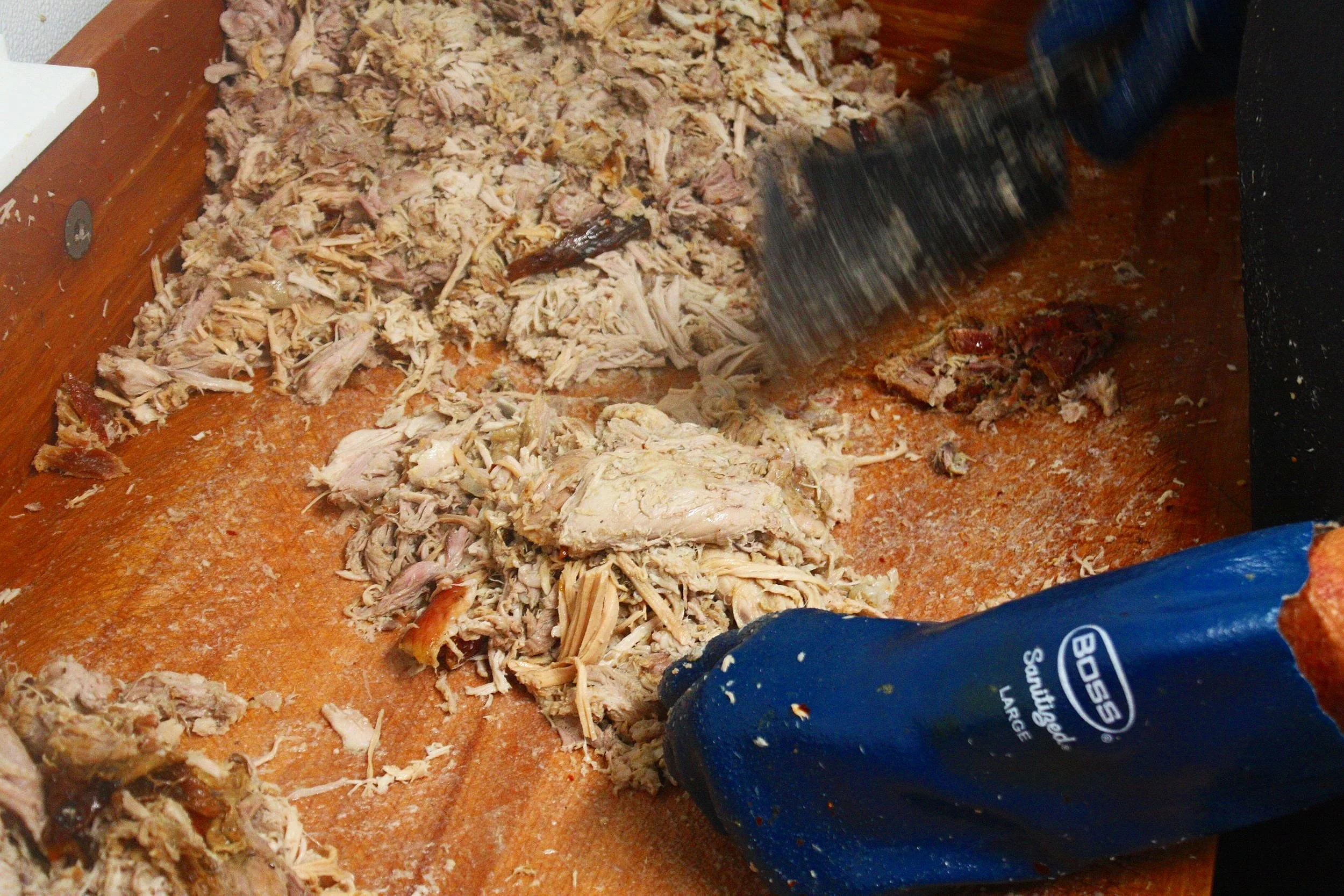  Hand-chopping our whole hogs that have cooked for 13+ hours over our open pits. 