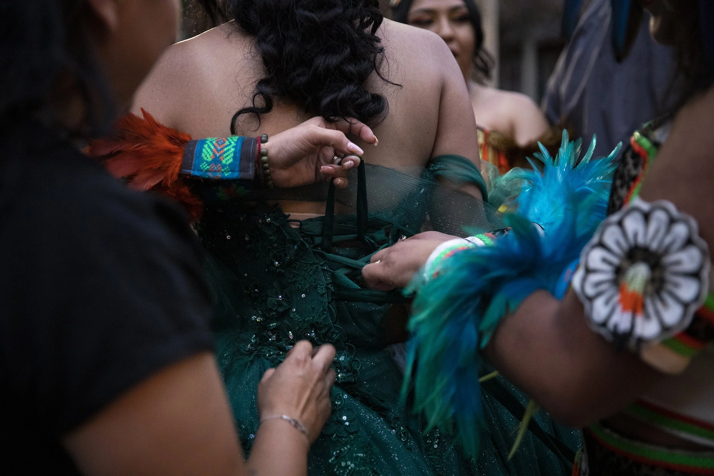 Friends and relatives help Zoey Mary Jane Grande change from a quinceañera dress into an Aztec dress. 