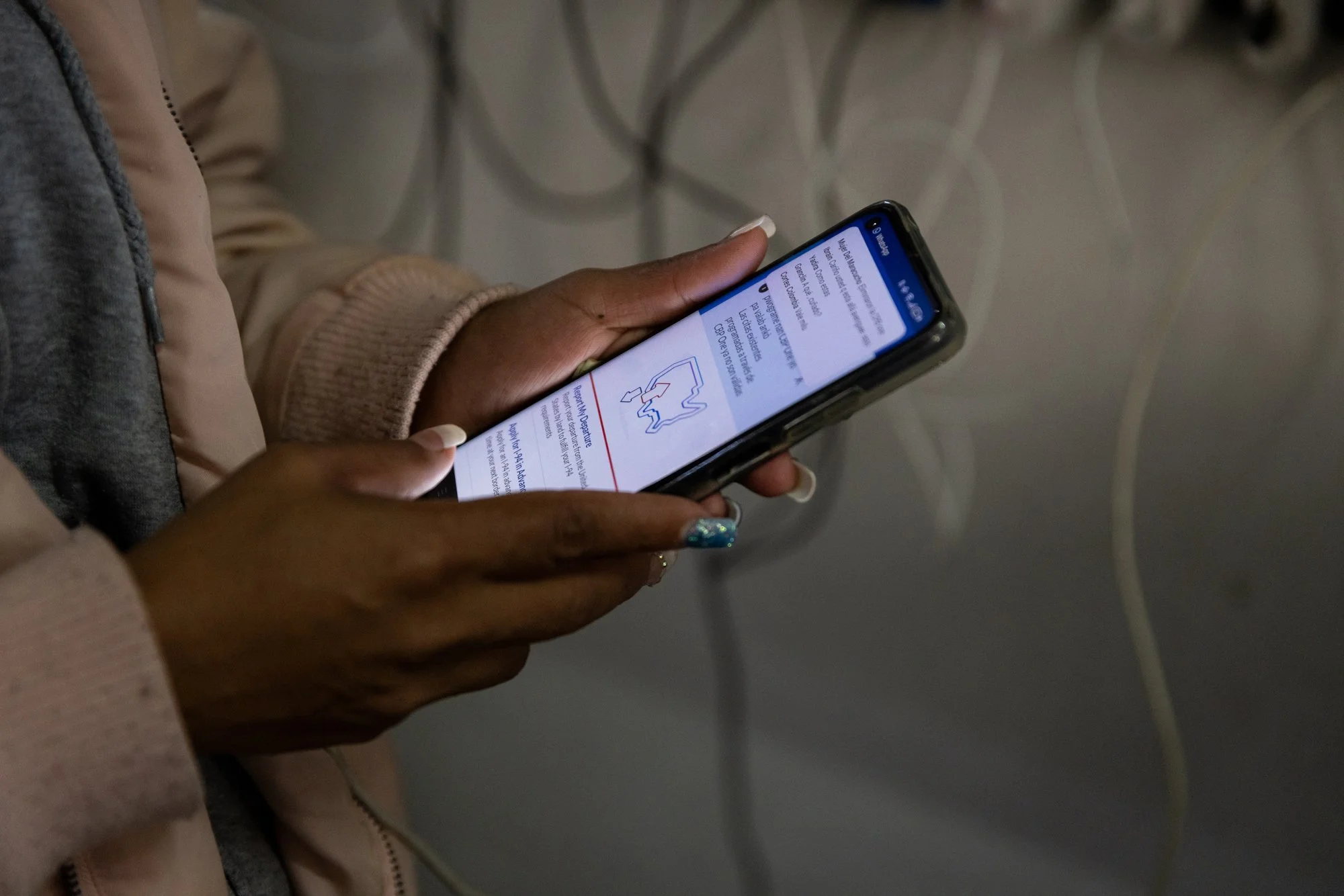 Milagro Gonzalez checks her phone to confirm that her CBP One appointment is still tomorrow after watching President Donald Trump's inaugural speech on television at Juventud 2000 shelter on Monday, Jan. 20, 2025 in Tijuana, Mexico. Ins