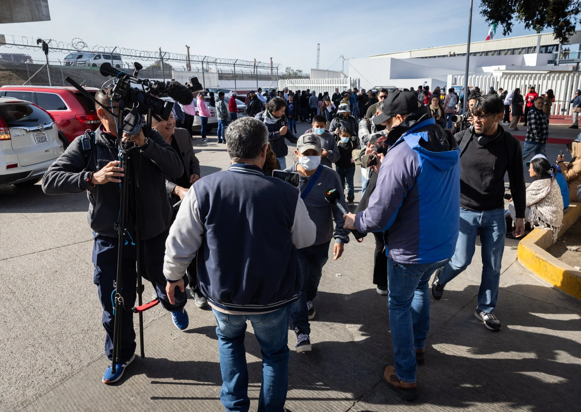 News crews swarm a group of migrants who were returned to Mexico on Monday, Jan. 20, 2025 morning in Tijuana.