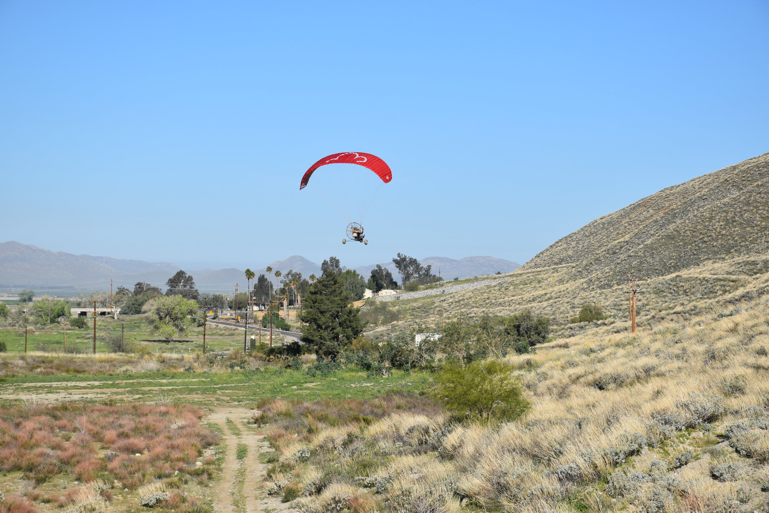 red paraglider touching down, Soboba Flight Park, learn paragliding and paramotoring at our camp