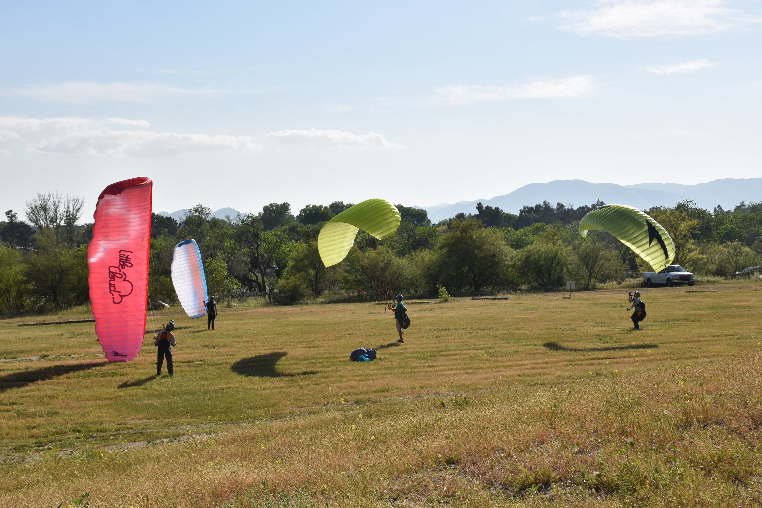 four paragliders in a field, Soboba Flight Park, learn paragliding and paramotoring at our camp