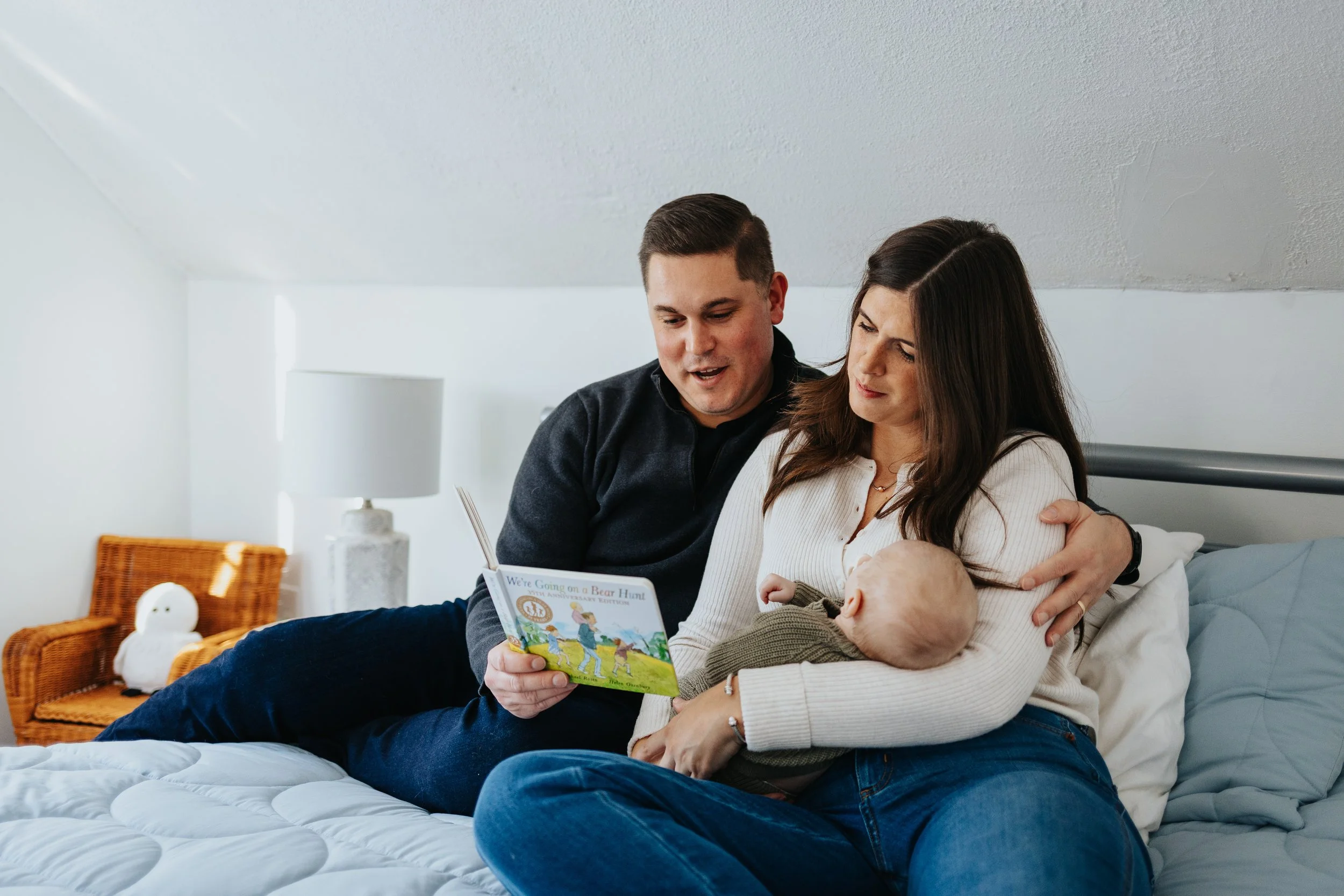 Family reading on bed during a lifestyle family portrait session in Lancaster MA.