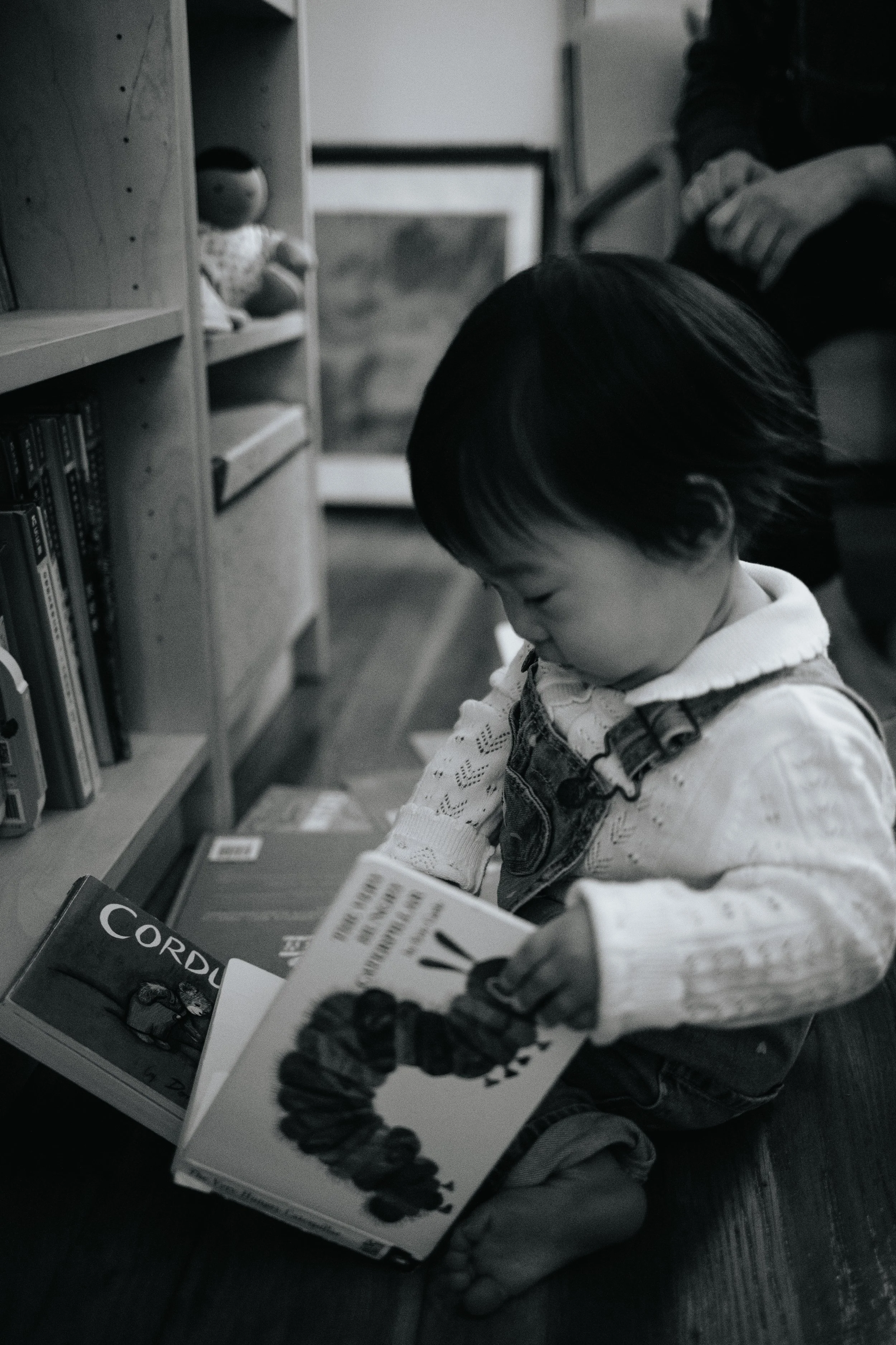 Black and white photo of baby reading during lifestyle family session in Grafton, MA.