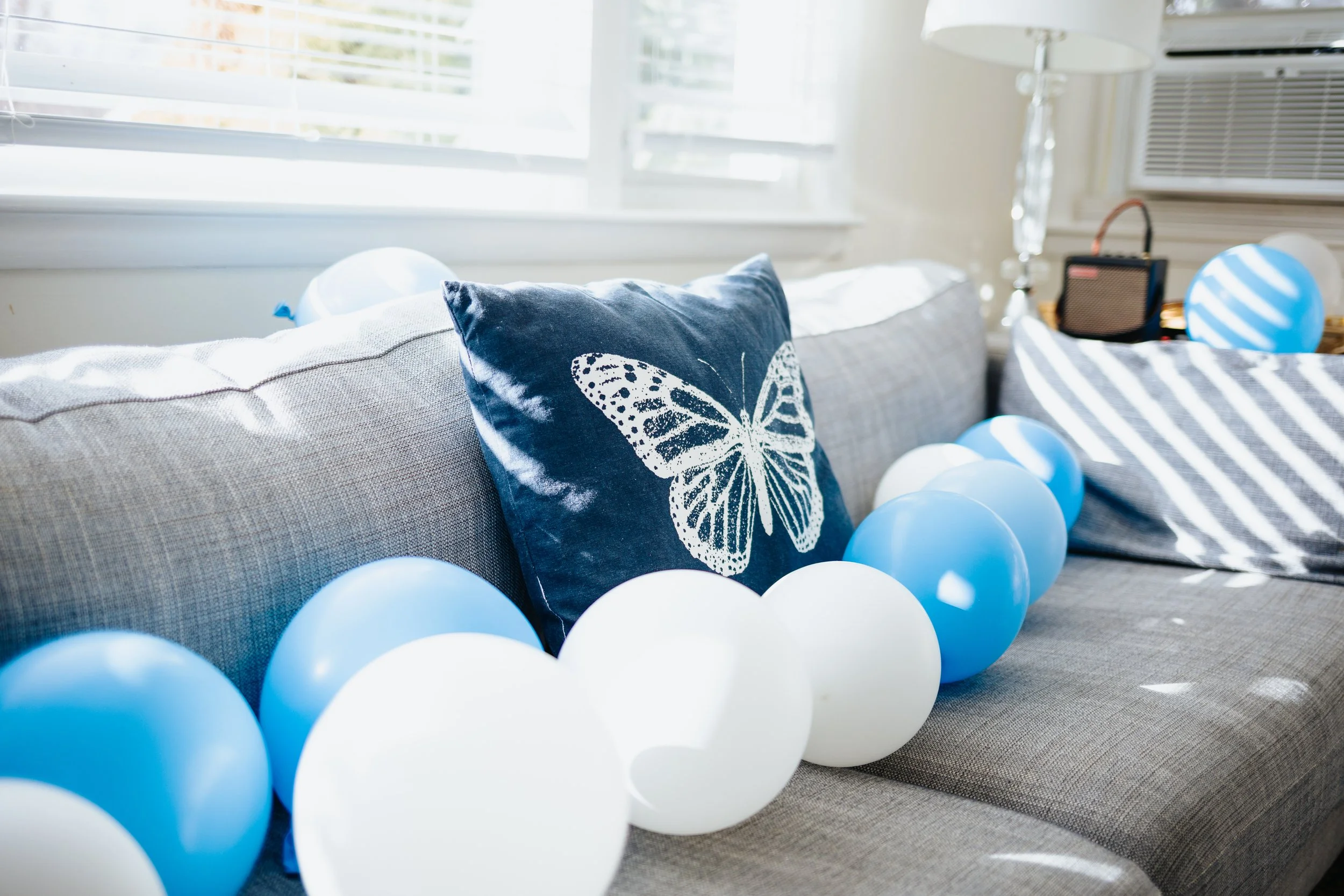 Birthday balloons and pillow on couch during Grafton lifestyle session.