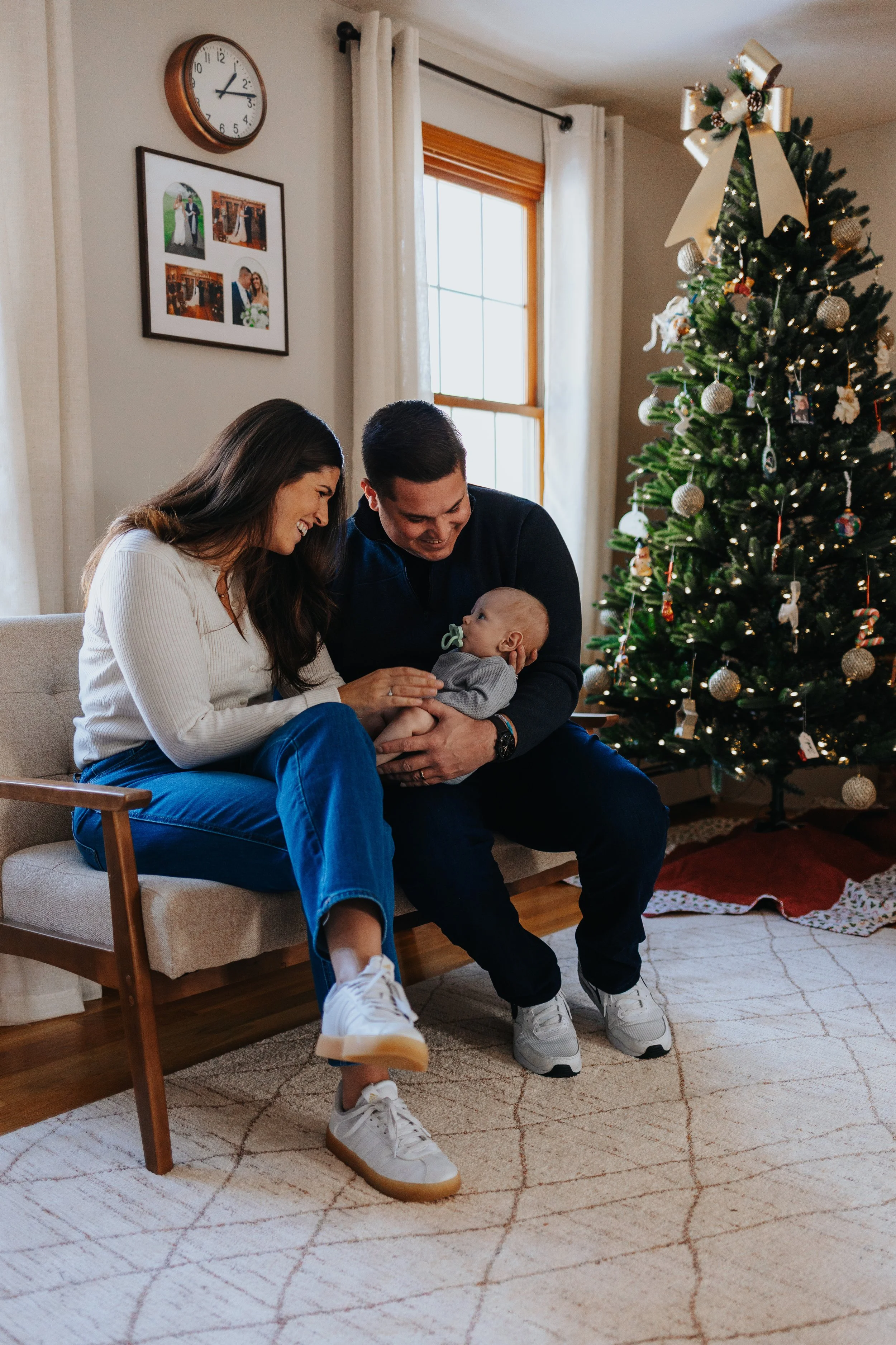 Family sitting on bench with baby during a lifestyle family portrait session in Lancaster MA.
