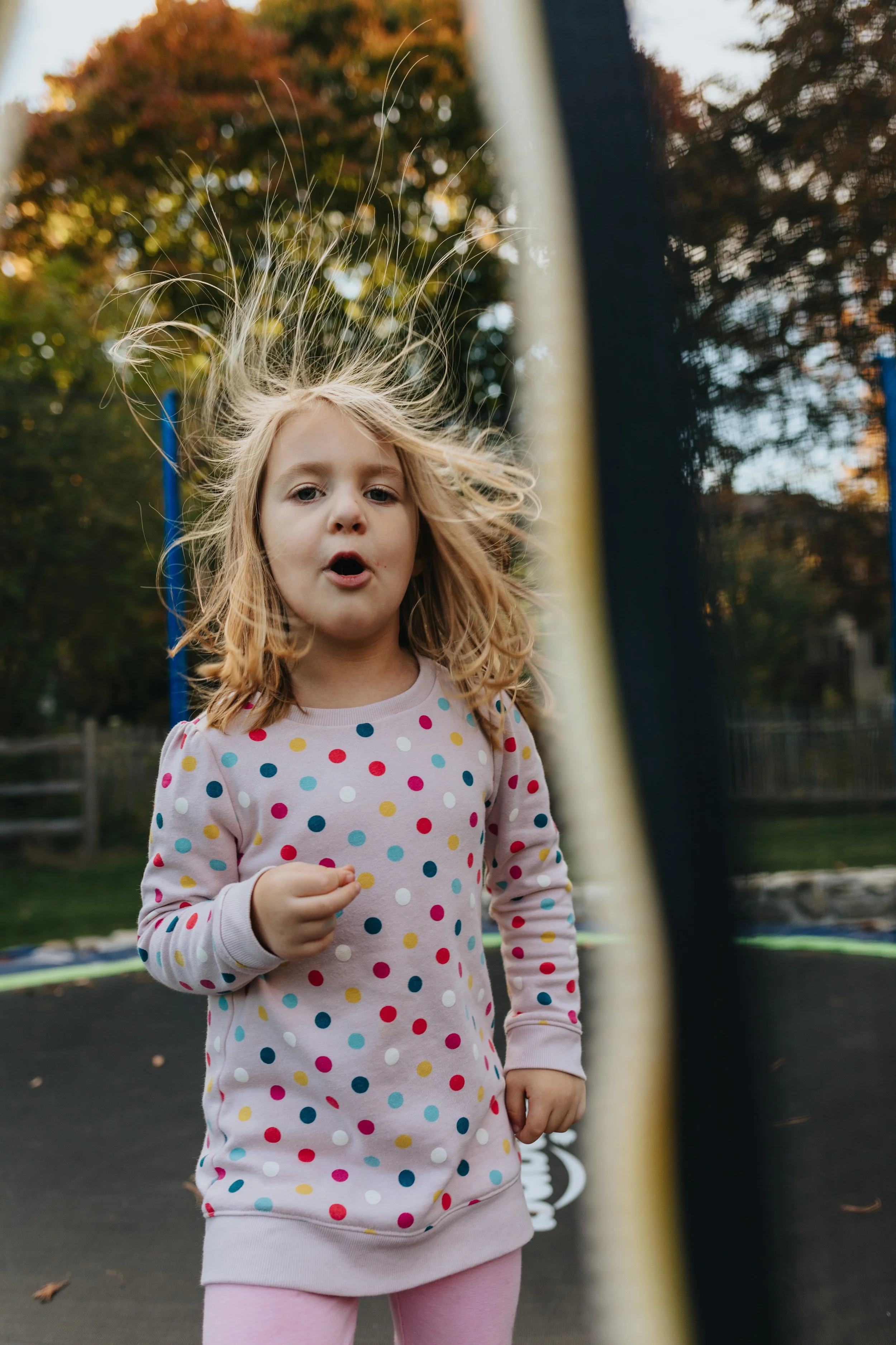 Candid family portrait of girl jumping on trampoline in Shrewsbury, MA by Worcester family photographer Tom Godfrey Photography.