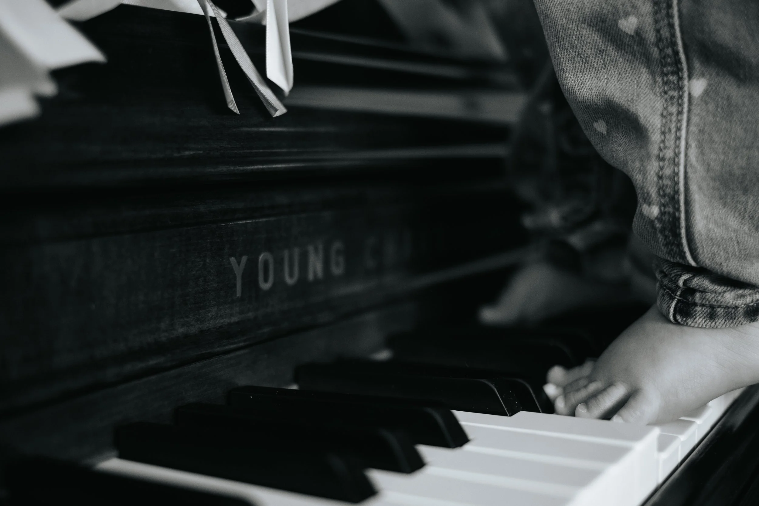 Close-up photo of baby stepping on piano during lifestyle session in Grafton.