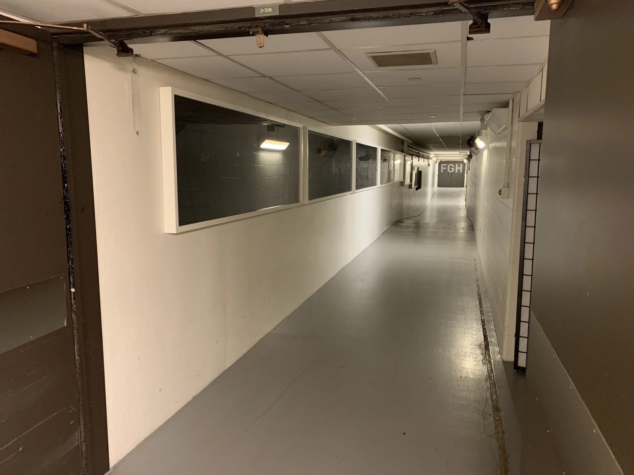  Before photo of the second half of the hallway before the cases were removed, the walls were painted, the new lights were installed, and the graphics were installed. 