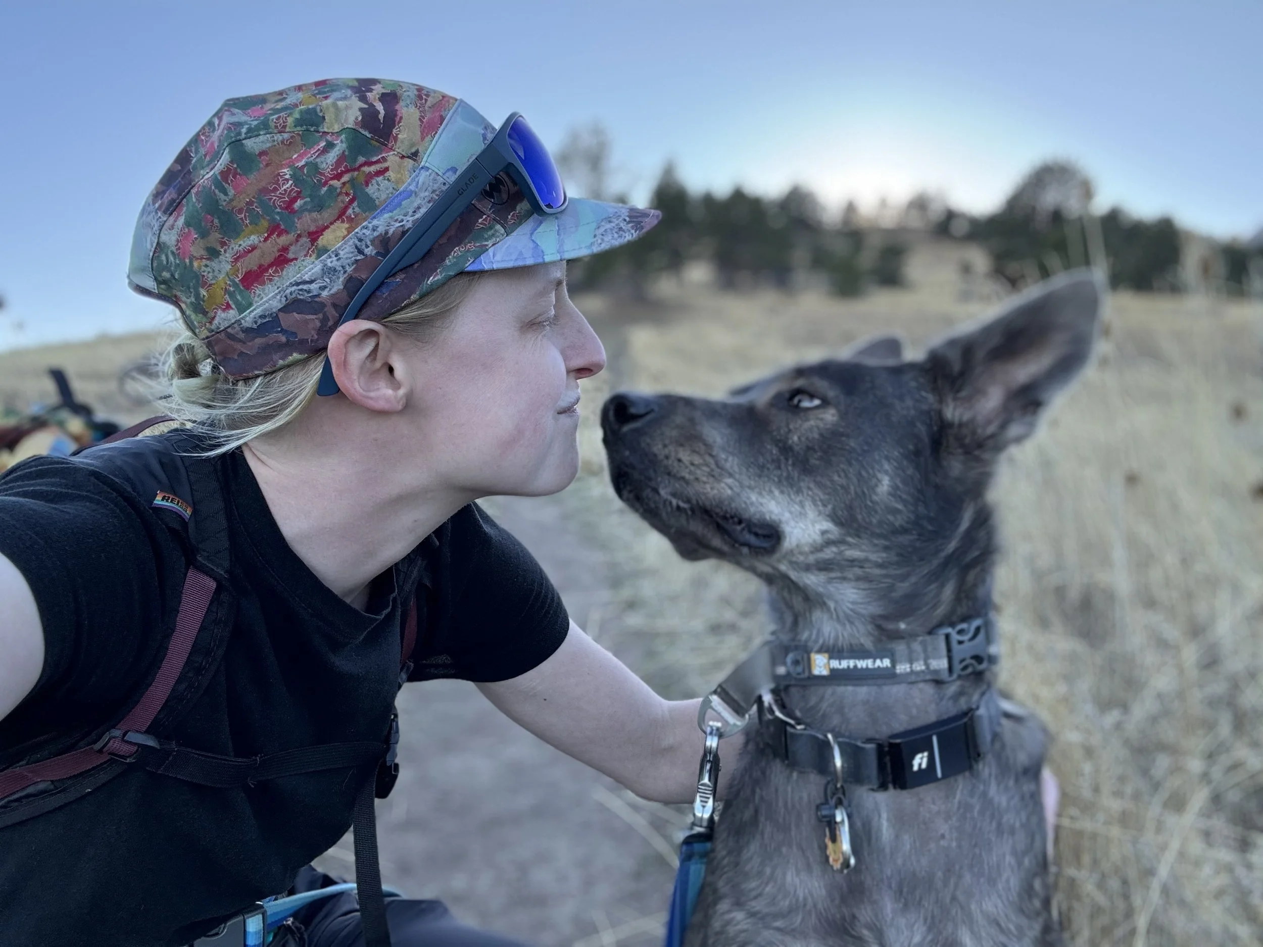 image of joey lodge and their dog looking at each other with grasslands in the background