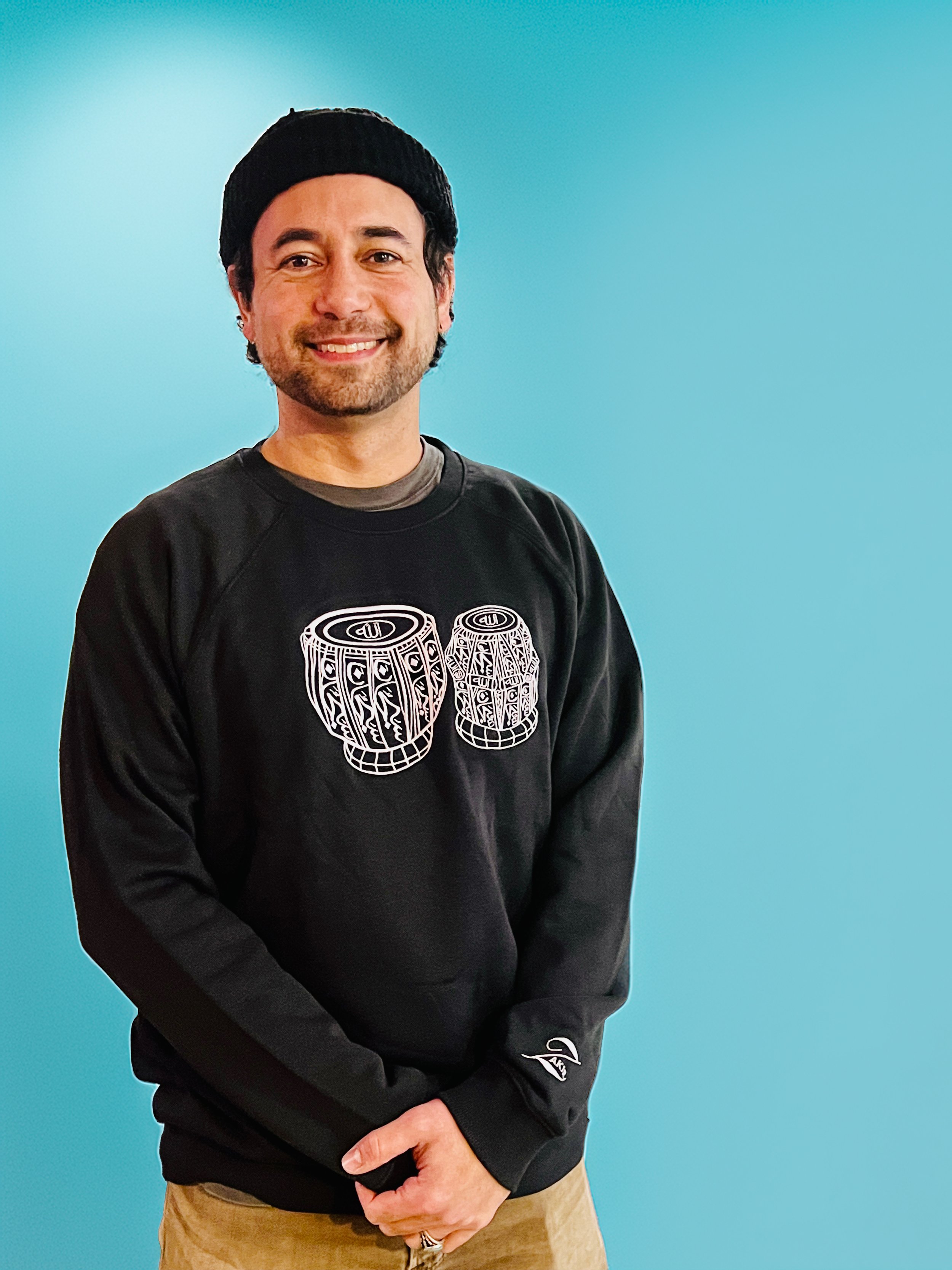 Manik Khan wearing the embroidered Subhanallah Tabla sweatshirt by Ihsan Ishan Design, celebrating Indian classical music and Hindu-Muslim unity.