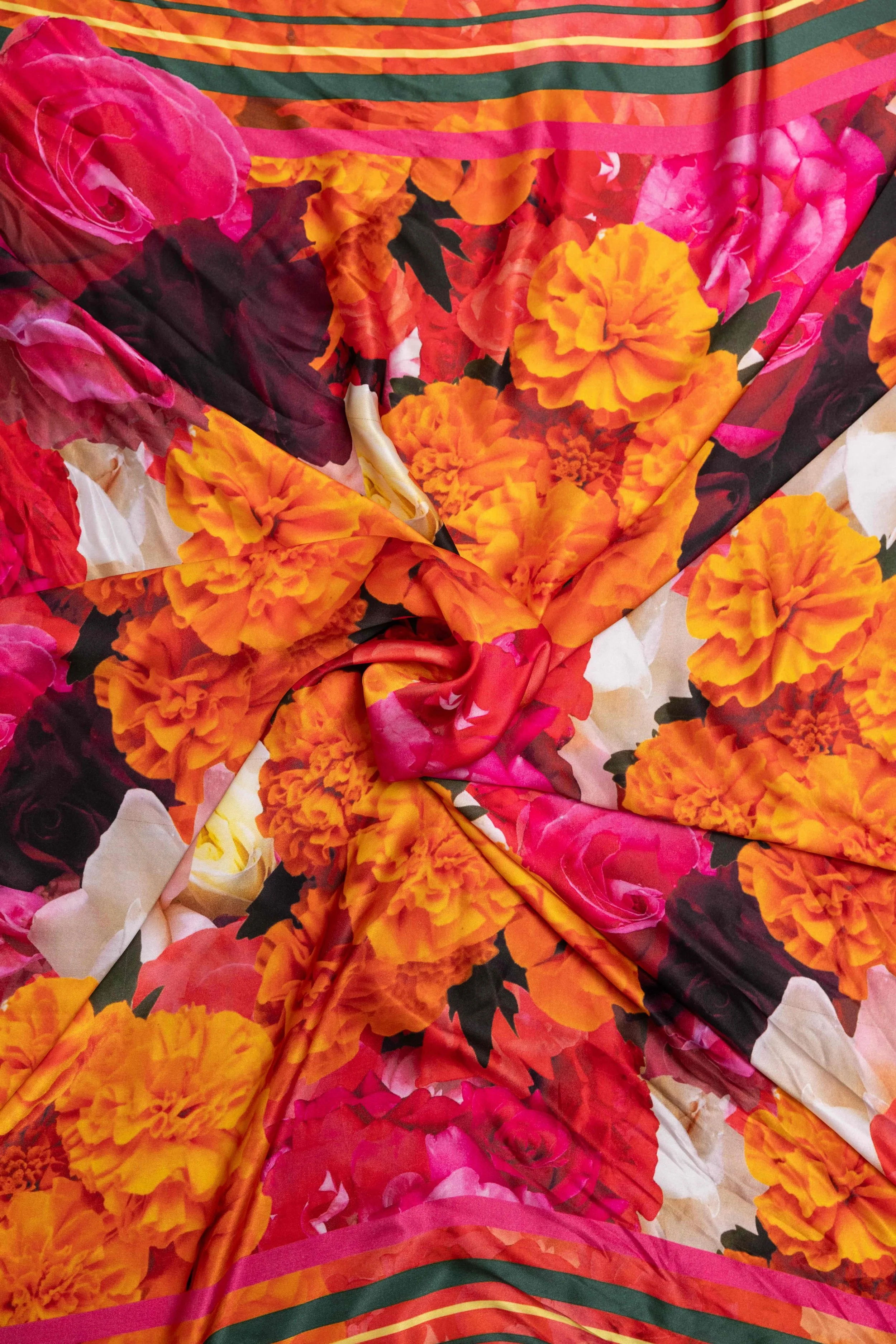 Close-up detail of Ihsan Ishan Design floral silk scarf showing the fabric texture and richly colored orange marigold and pink rose print.