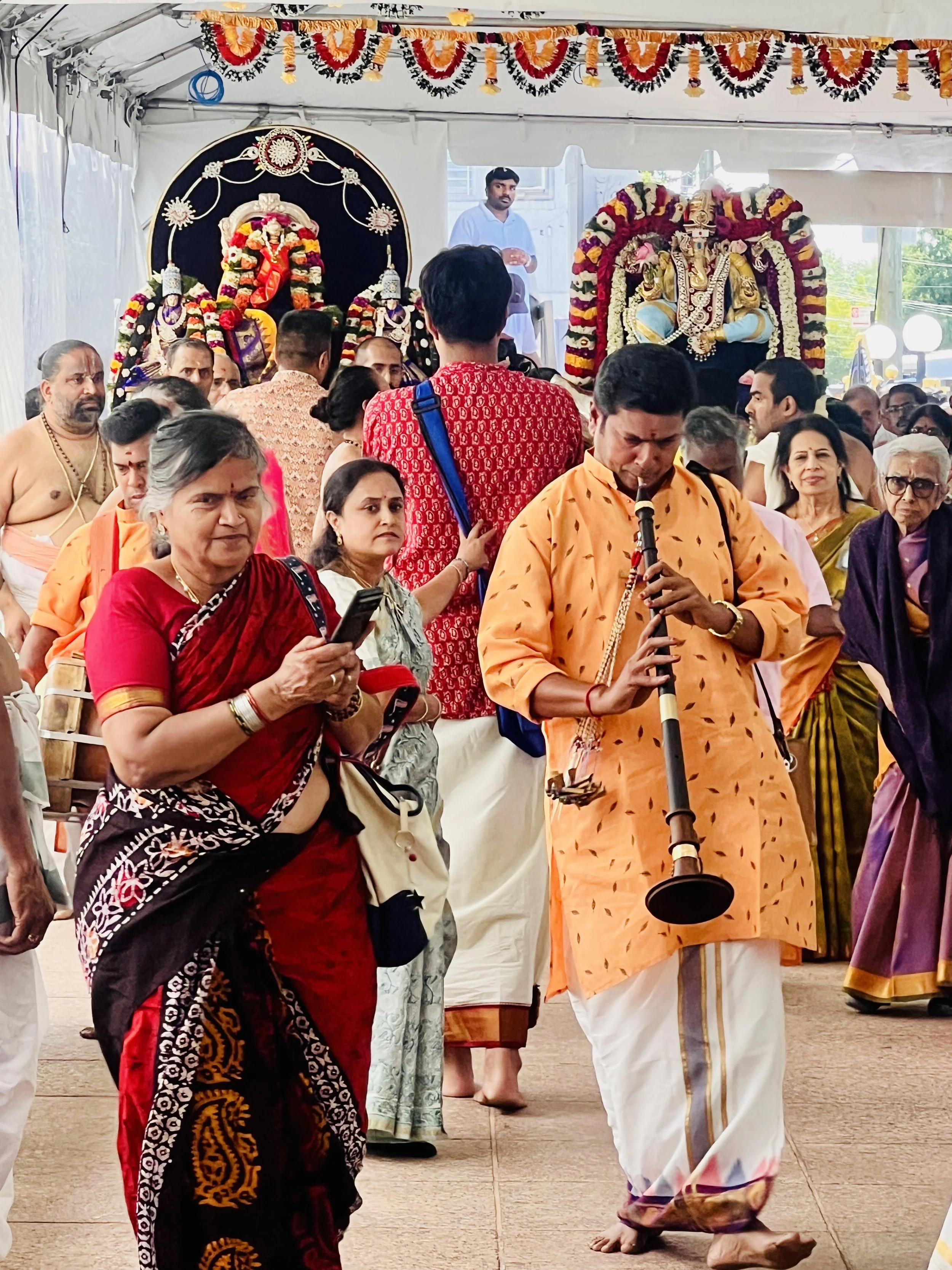Hindu worshippers and a traditional musician during a religious ceremony at the Hindu Temple Society of North America’s Ganesha Temple in Flushing, New York.