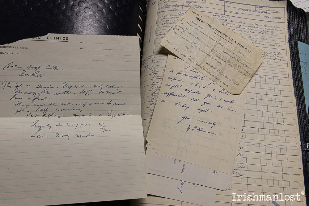 Open notebook with handwritten notes, several old receipts or pieces of paper placed on top, and a medical chart with handwritten entries.