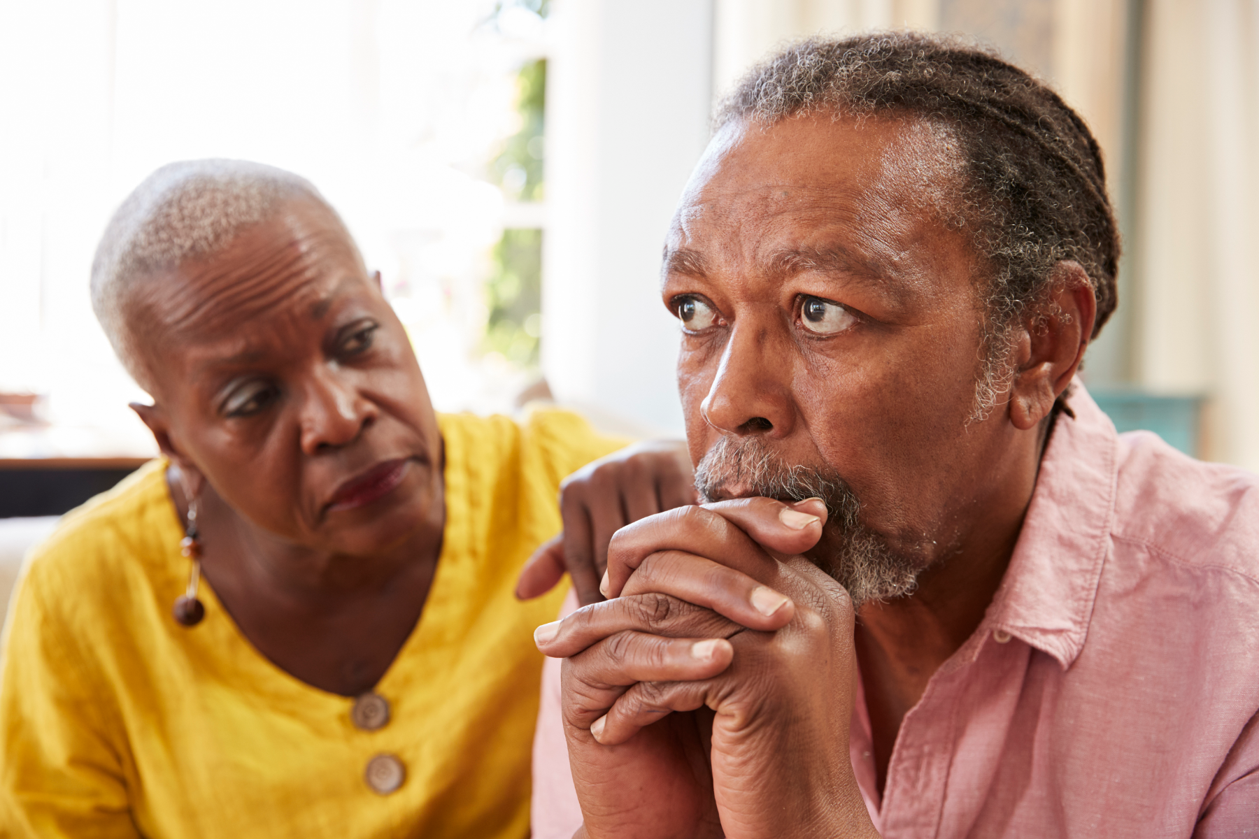 senior_woman_comforting_man_with_depression_at_home.png