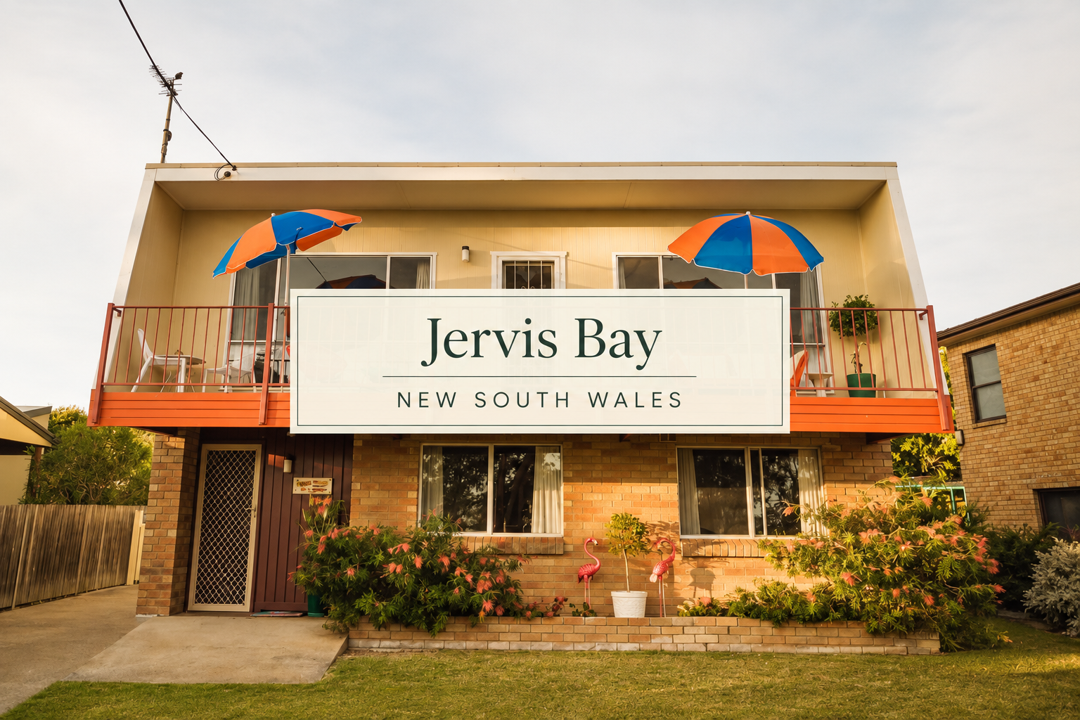 Jervis Bay op shop and vintage treasure guide, featuring a colourful retro coastal home with a bright orange balcony, blue and orange umbrellas, flowering gardens and vintage flamingo ornaments in New South Wales.