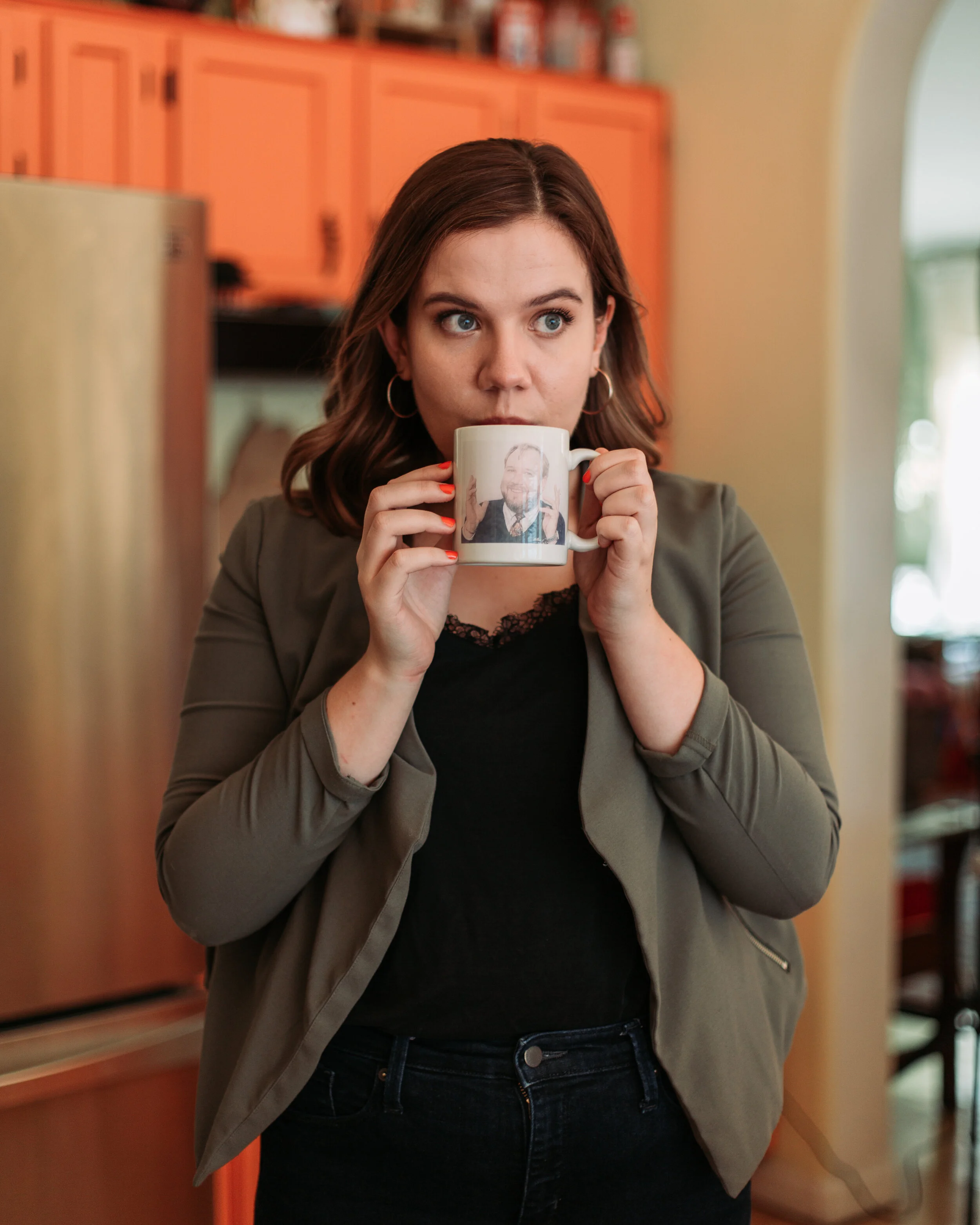 Taking a sip out of a mug featuring her dad from the ‘90s. Photo taken by Holly Beaupre.