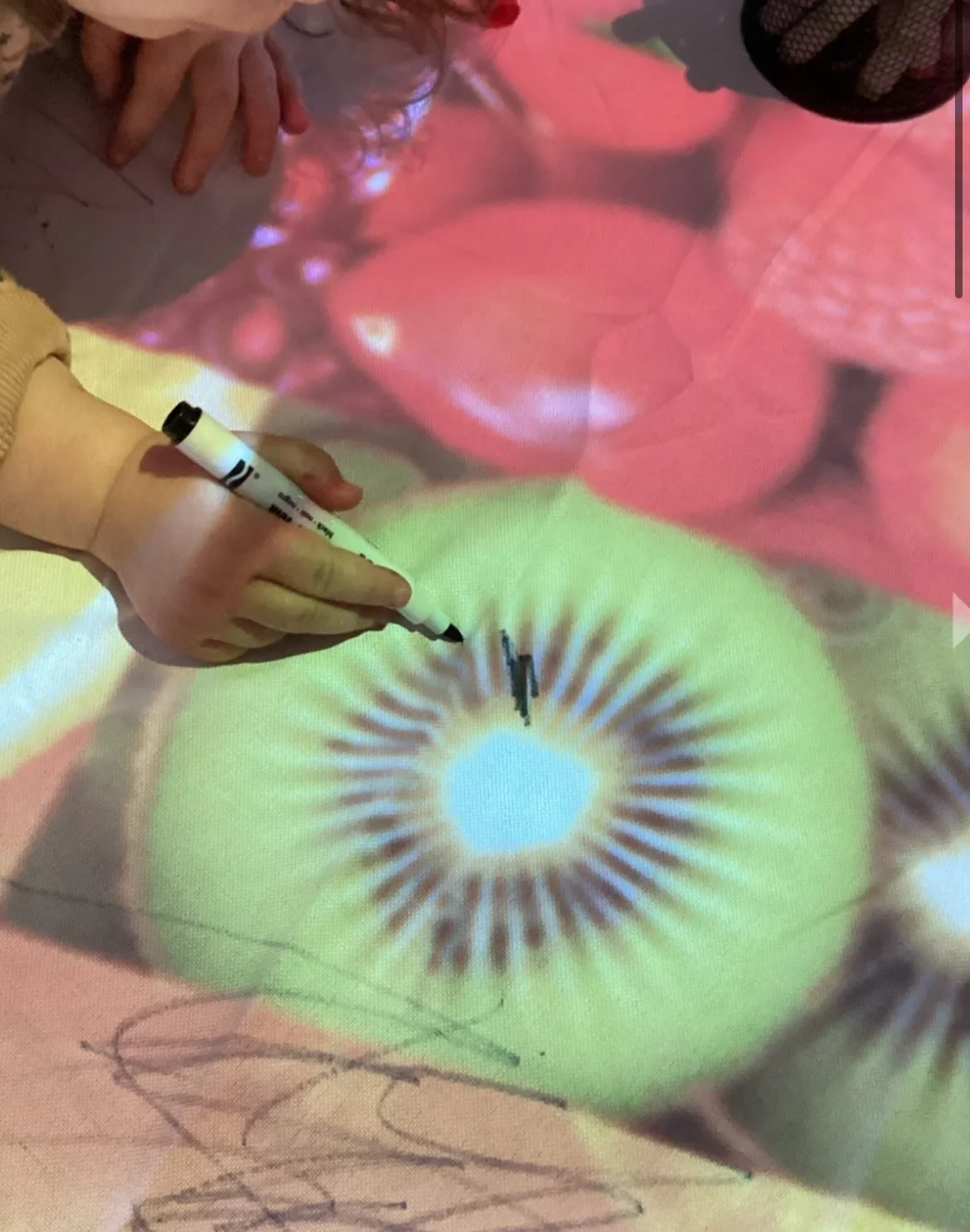 🎨🍊✨ Creativity came to life in our Toddler space as the children designed their own table cloths using projected images of fruit and light.
&nbsp;
Using a projector to cast colourful fruit images onto the table, the children explored mark making, c