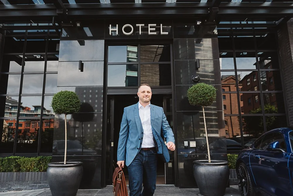 workplace natural photograph of man walking out from a meeting at a hotel in manchester