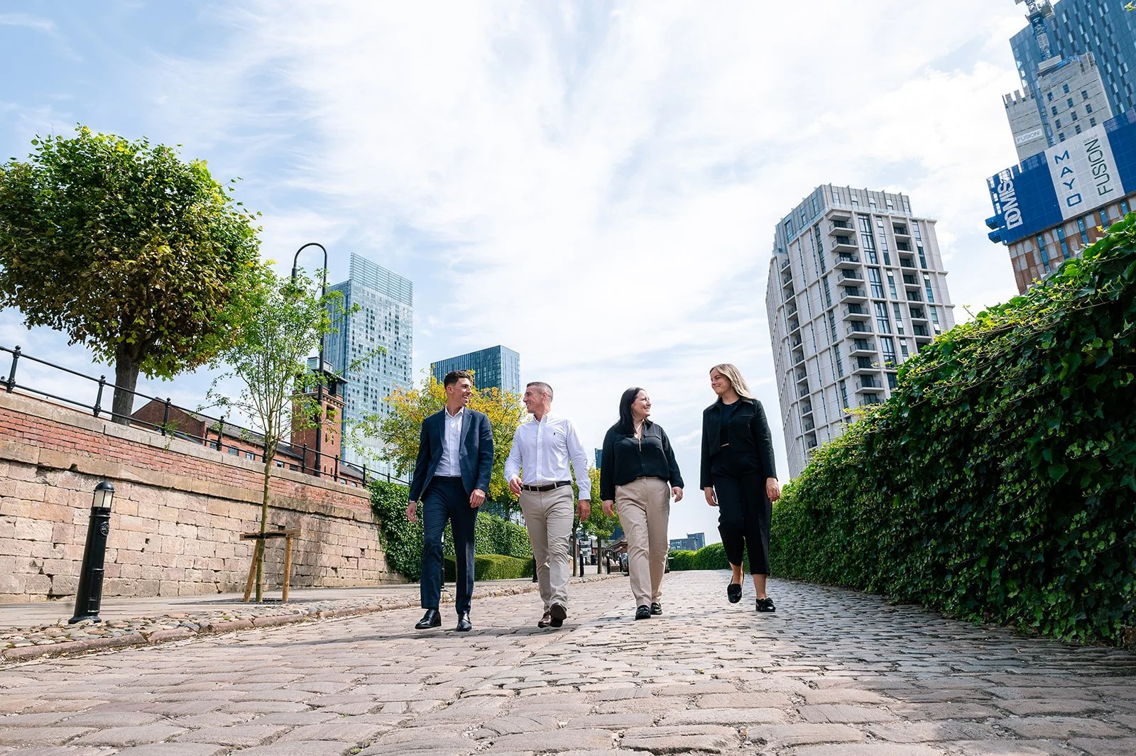 business people walking together through castlefield manchester chatting candid