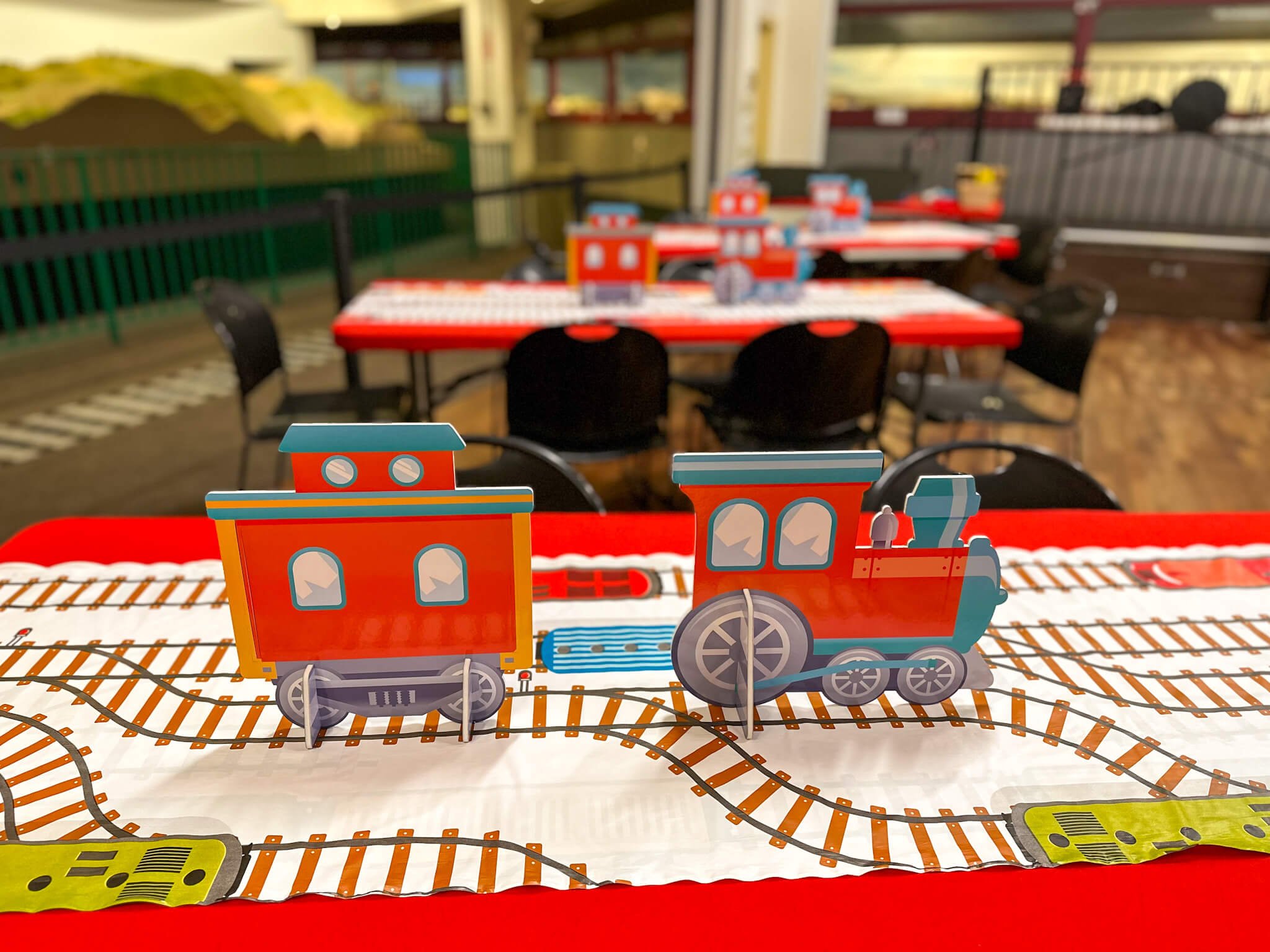  a close up of train-themed decorations on a red table 