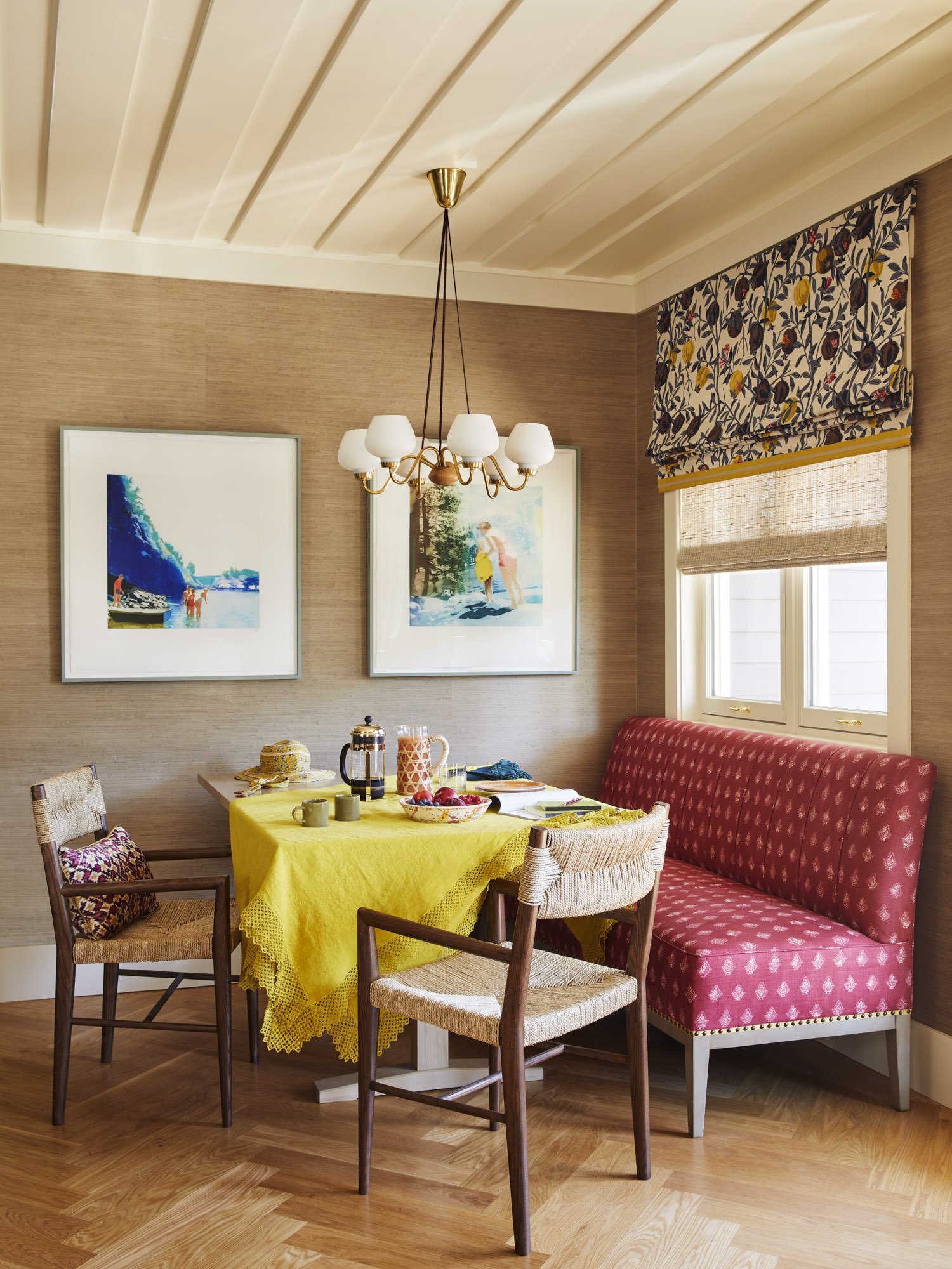   THE BREAKFAST NOOK INCLUDES HERRINGBONE OAK FLOOR, GRASS-CLOTH WALLPAPER, A VINTAGE ITALIAN CHANDELIER, AND A CUSTOM TABLE BY YELLOWSTONE TRADITIONS. THE BANQUETTE IS UPHOLSTERED IN BLOCK PRINTED FABRIC FROM LISA FINE. THE WALNUT AND RUSH DINING CH