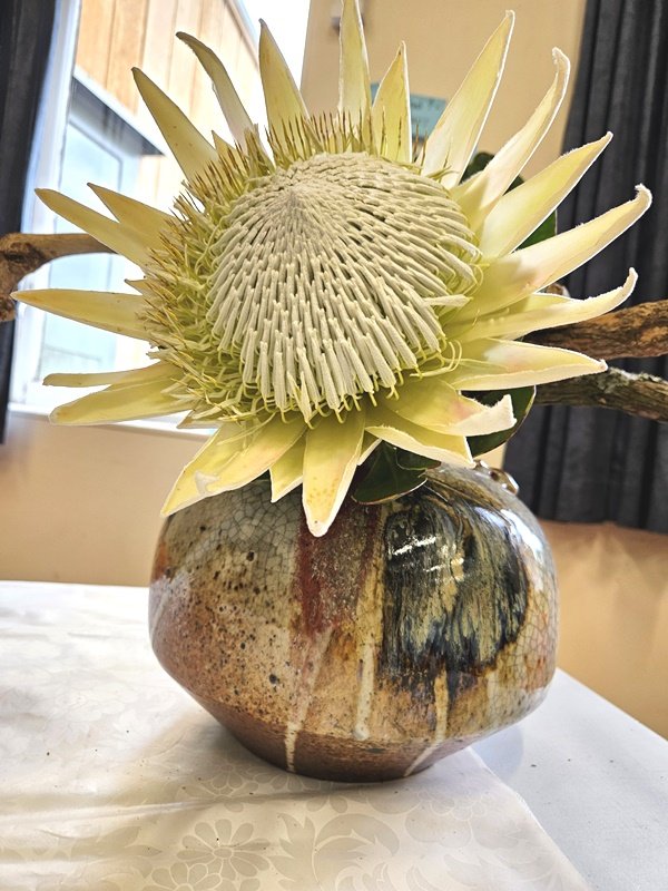 Alyson added a large protea to the branch placed horizonally on the container