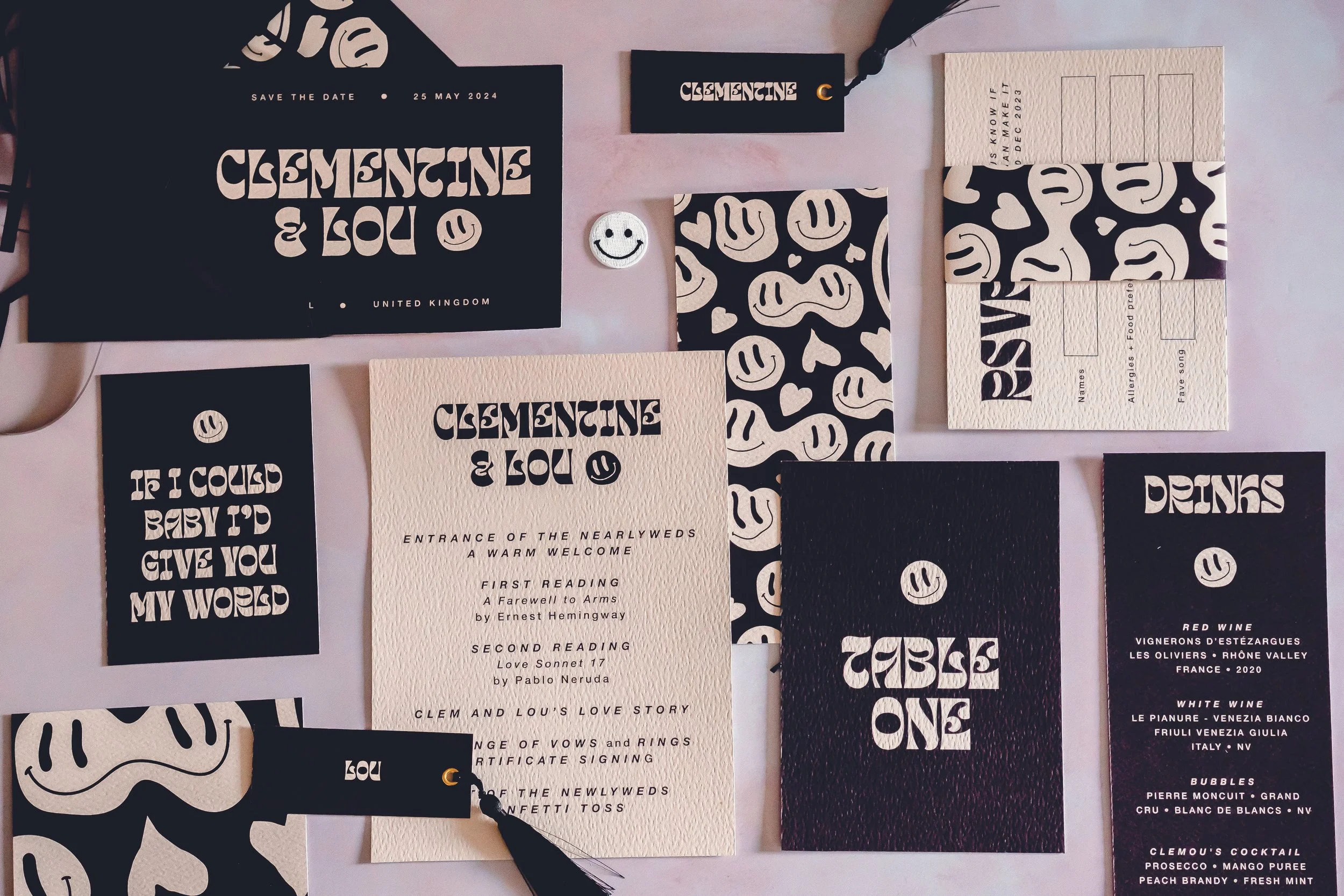 A black and white stationery suite of invites, menus, RSVP cards and orders of service featuring a funky smiley face pattern.