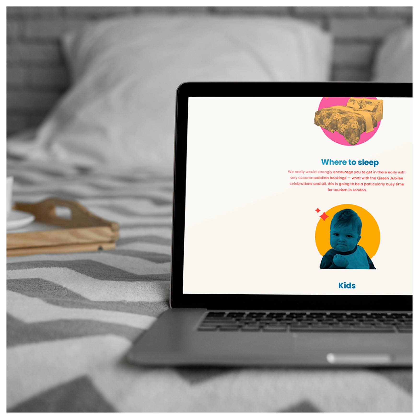 A laptop lays on a bed in a room with grey and white decor. Next to it is a wooden tray with coffee cups and saucers. The screen of the laptop shows a webpage with coloured photographs and information on where to stay and policy on kids for a wedding