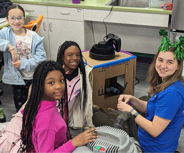Middle School girls engineering advancements in robotics.
