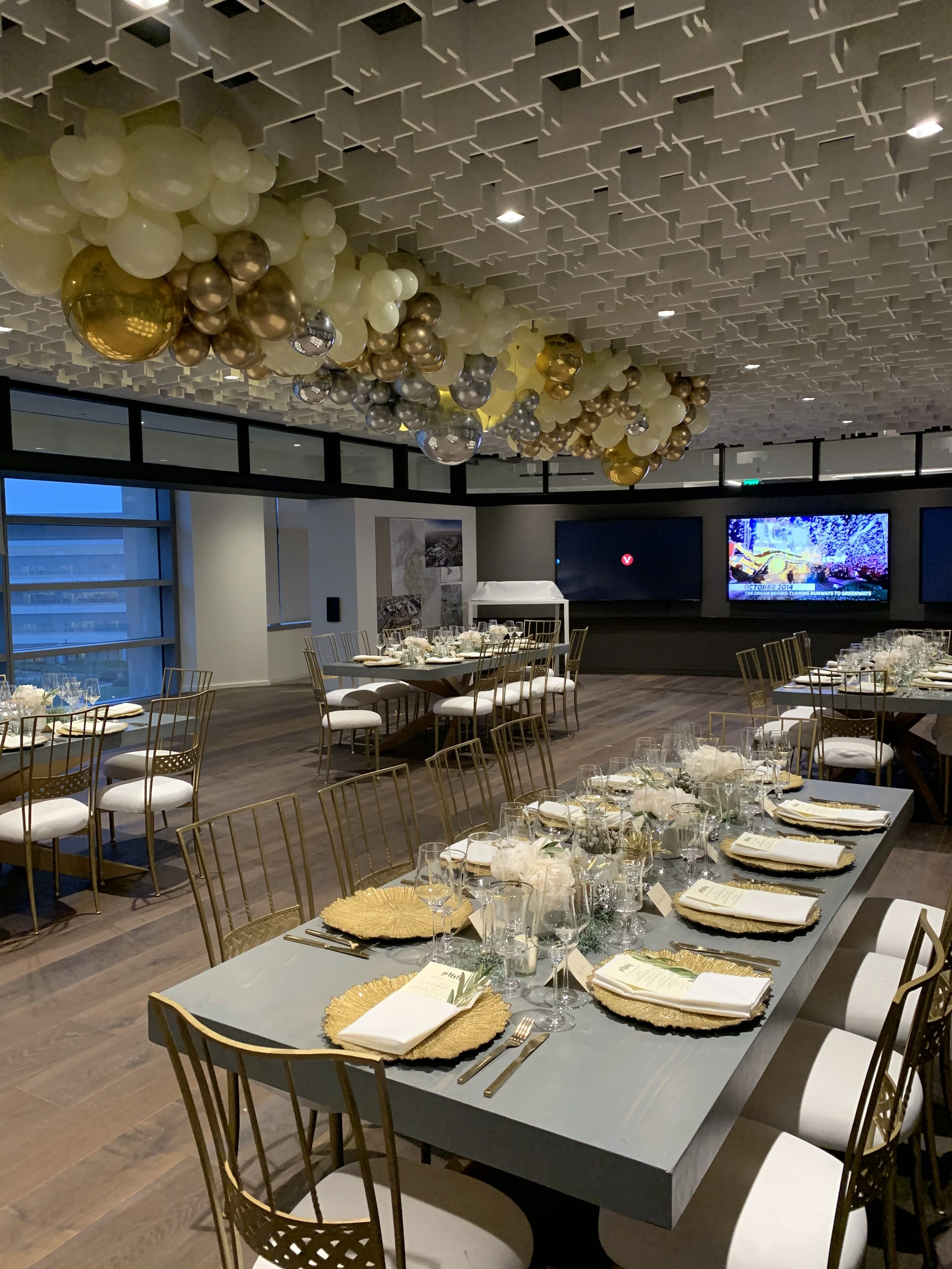 Elegant corporate dinner Fivepoint, featuring gold and silver balloons, high-end Catering, formal table settings, gold accents, floral centerpieces for a sophisticated special corporate event. 