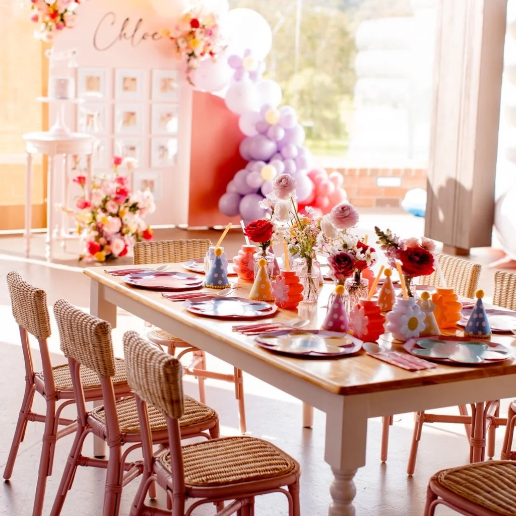 Elegant and pink floral themed first birthday with framed photo balloon backdrop and childrens table with themed centerpieces and matching party decor. 