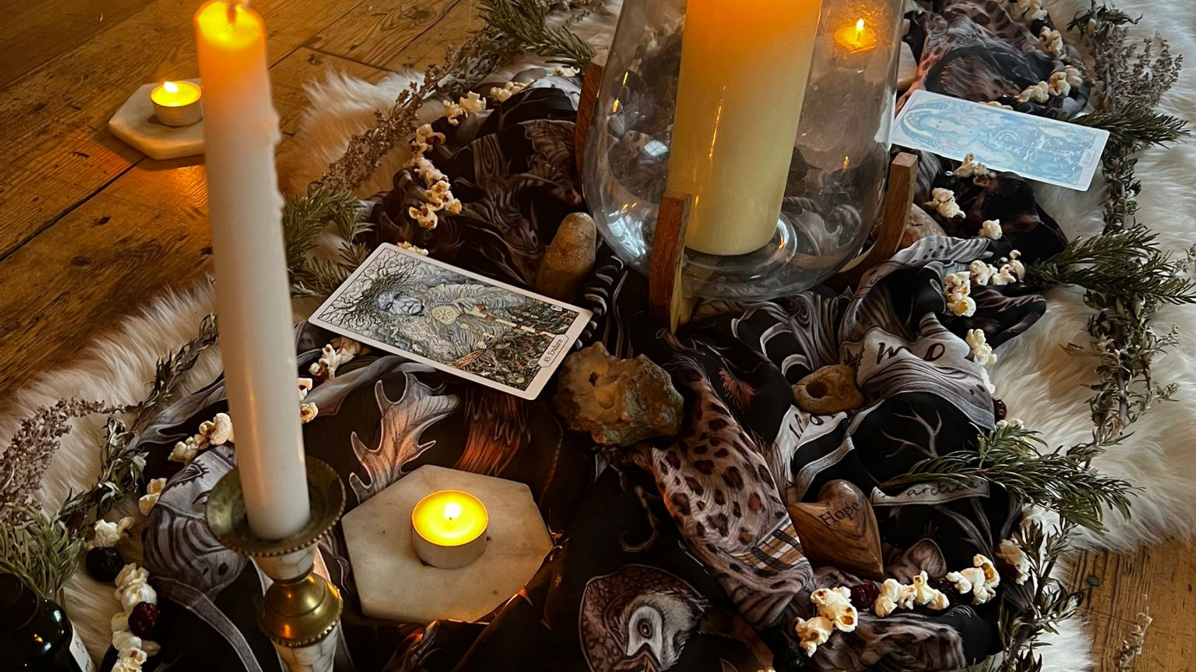 an altar with pillar candles, mugwort and oracle cards