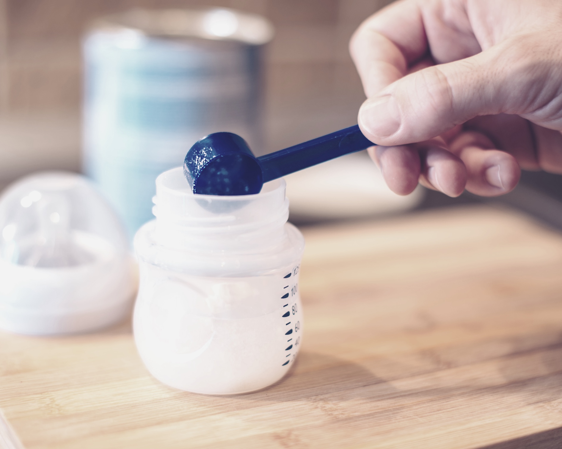 Image of formula being scooped into a bottle.