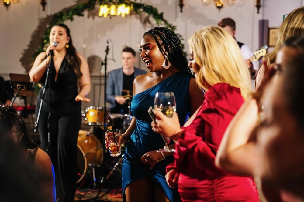 The Live Notes singers performing among wedding guests