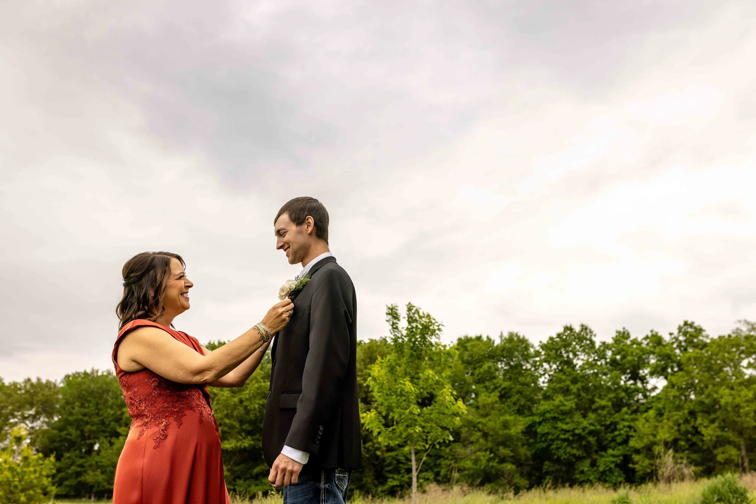 Placing the Groom’s Boutonniere at Walnut Ridge Venue
