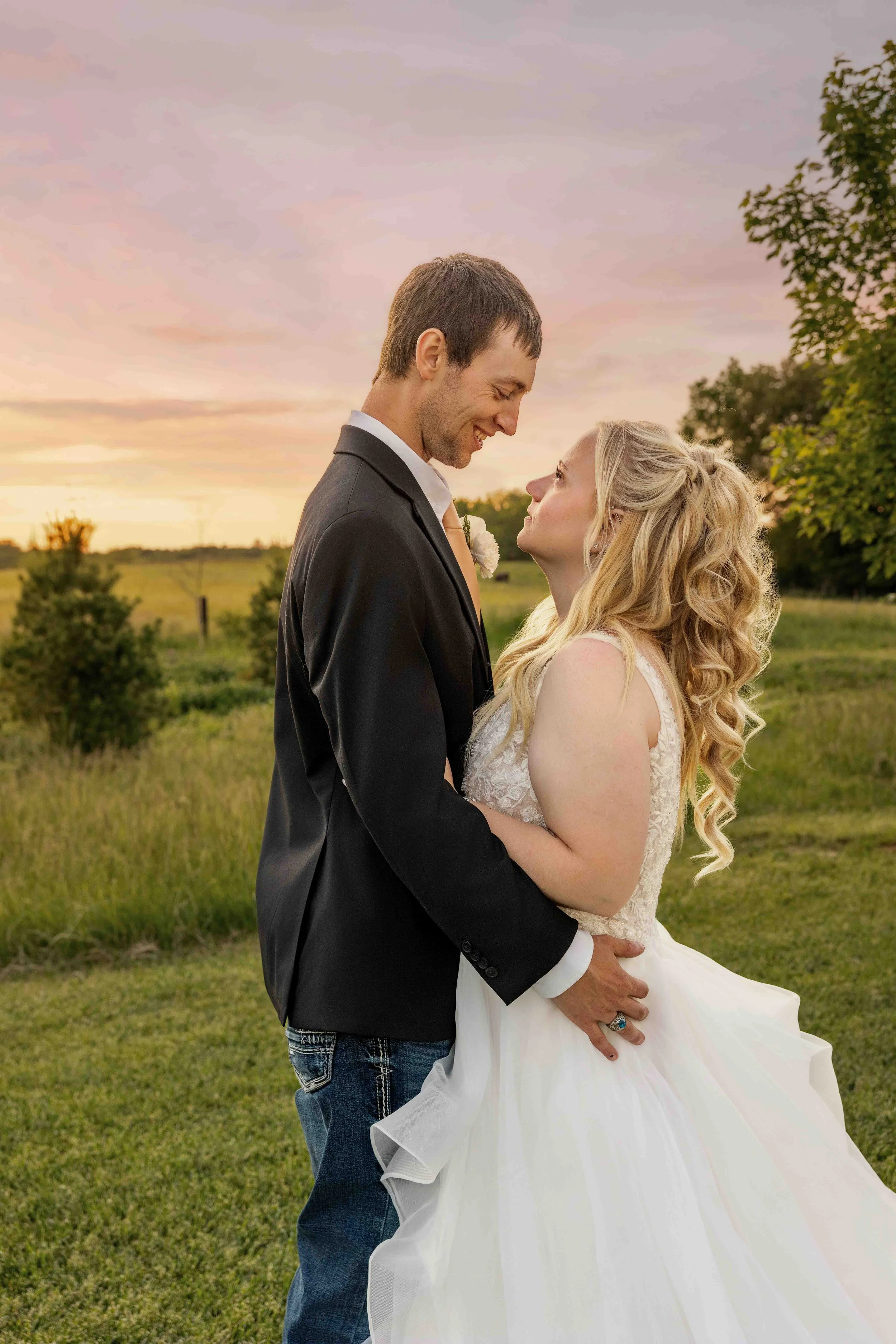Bride and groom embracing during portraits at Walnut Ridge Venue in Iowa.