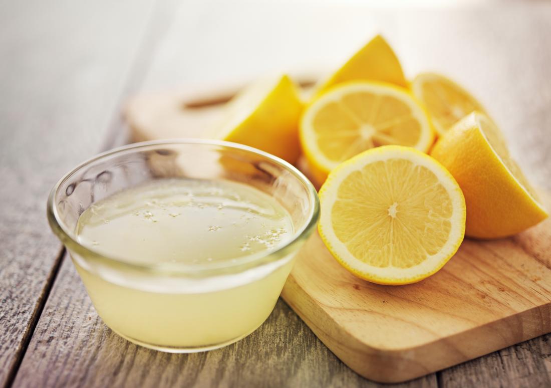 cut up lemons on chopping board with bowl of lemon juice