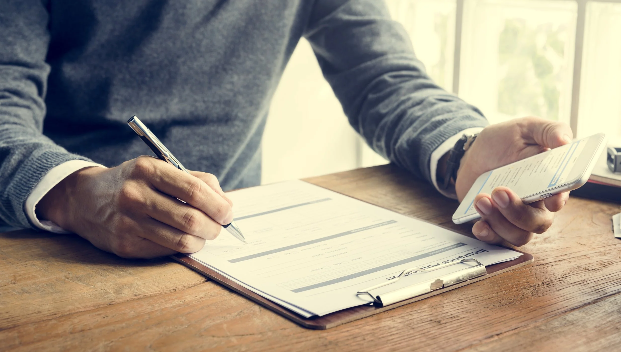 man-writing-insurance-application-form-concept-PVVSXKC.jpg