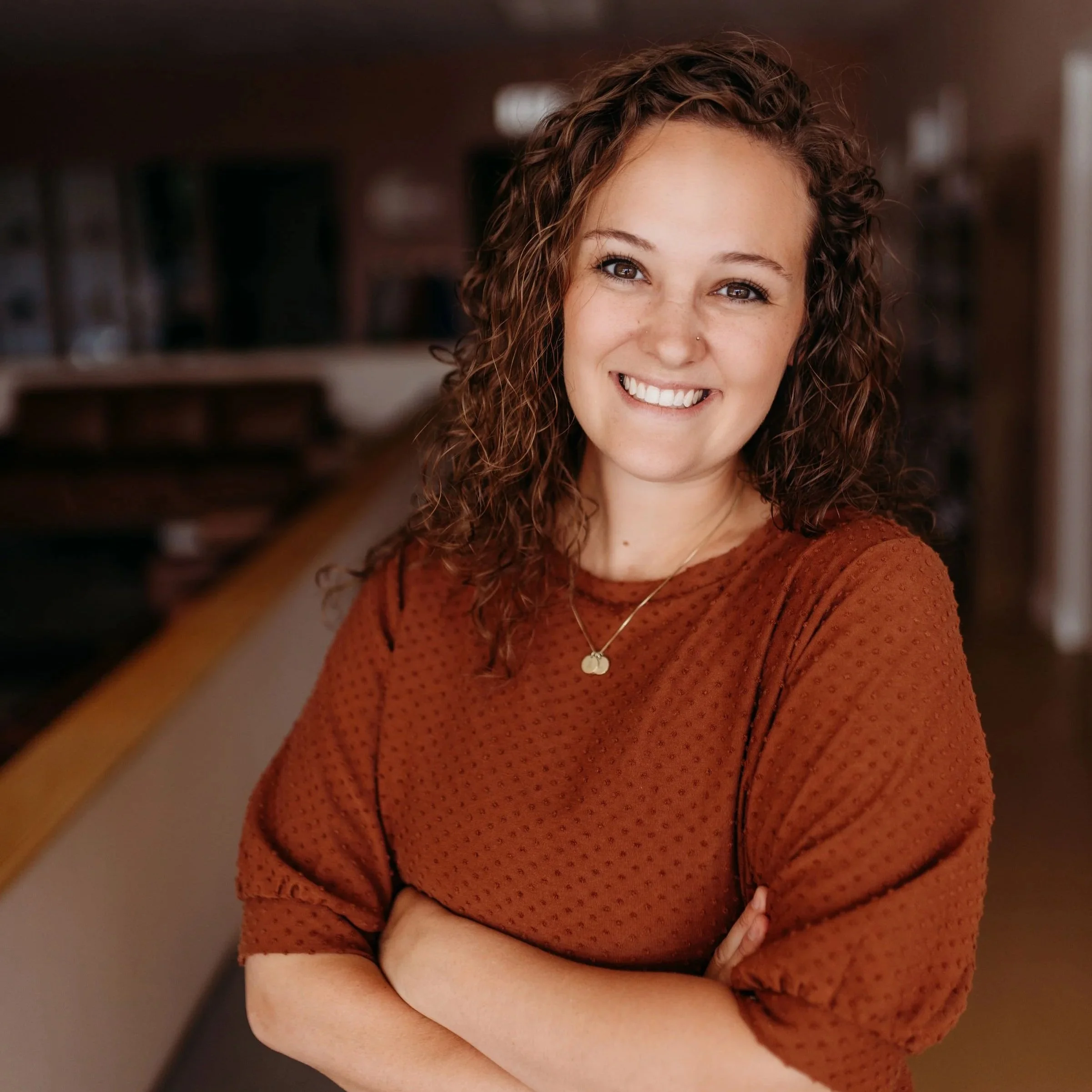 Jayme, an internationally board-certified lactation consultant (IBCLC) and registered nurse (RN), offering professional breastfeeding support in a natural, outdoor setting.