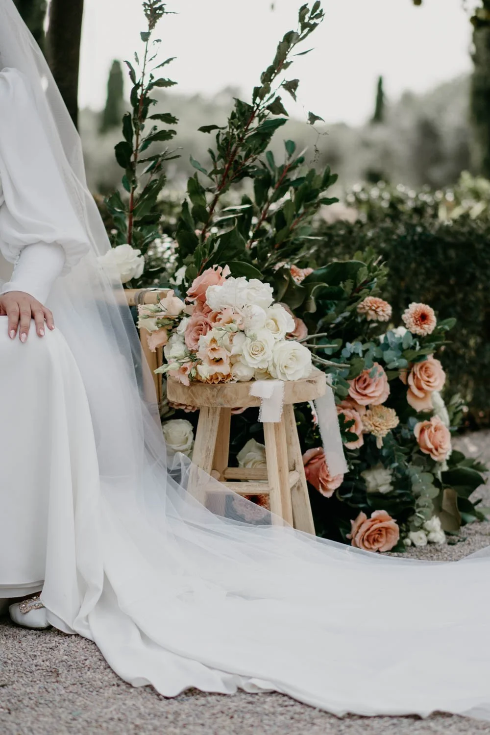Ram de núvia sobre banc rústic a l'Orangerie durant la cerimònia de boda
